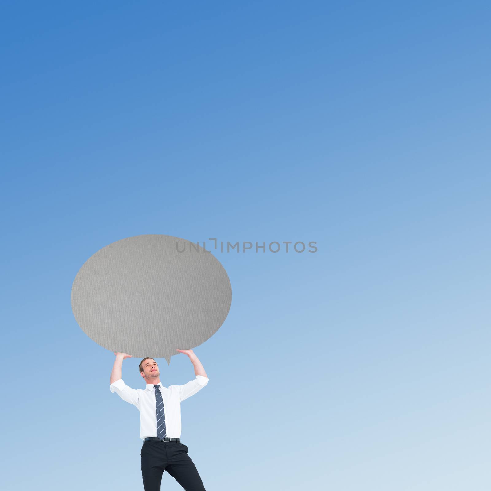 Businessman holding a speech bubble against blue sky