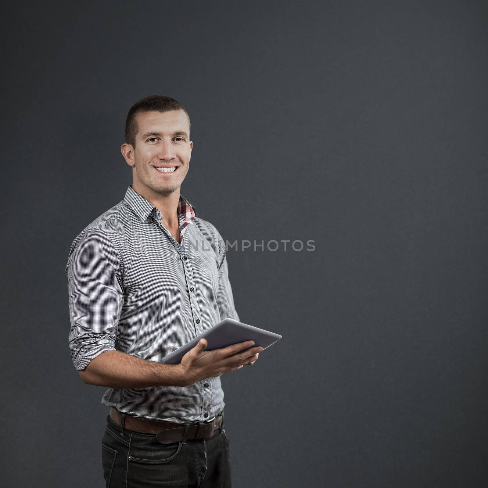Handsome businessman using digital tablet over white background against grey background
