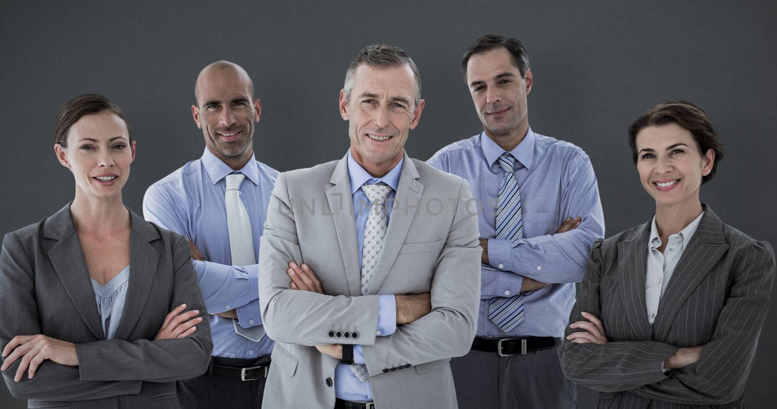 Business team working happily together on laptop against grey background