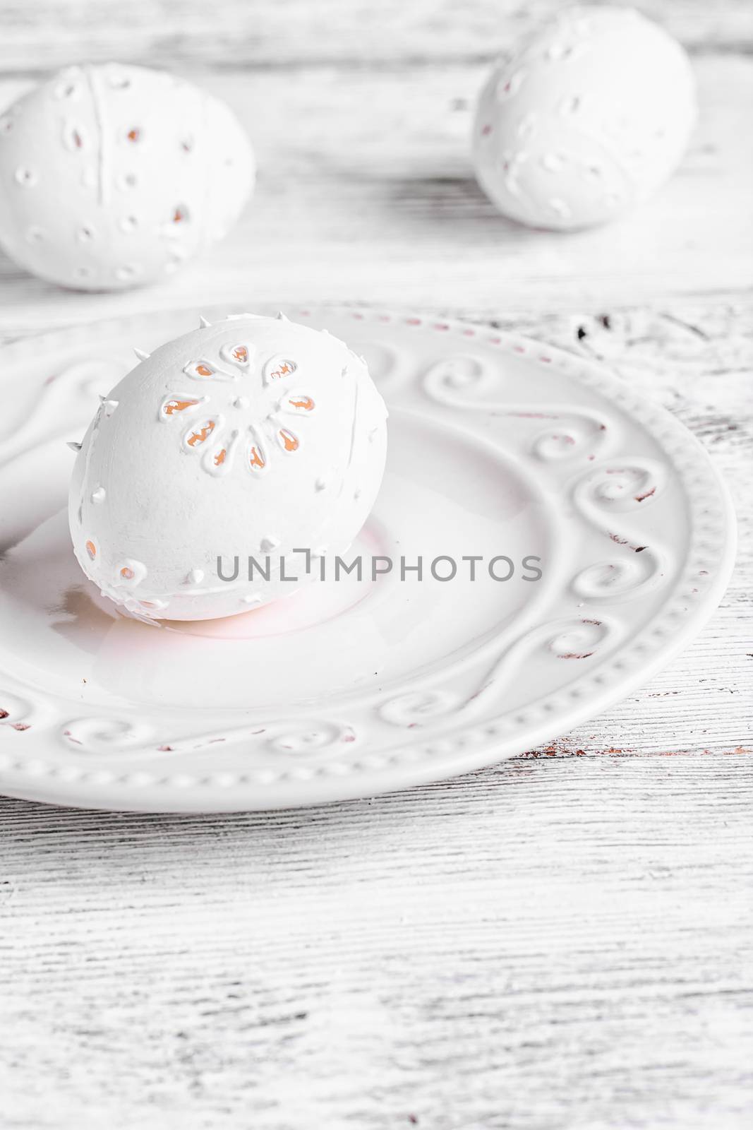 Decorative carved chicken egg for Easter to light the plate.Photograph high key.