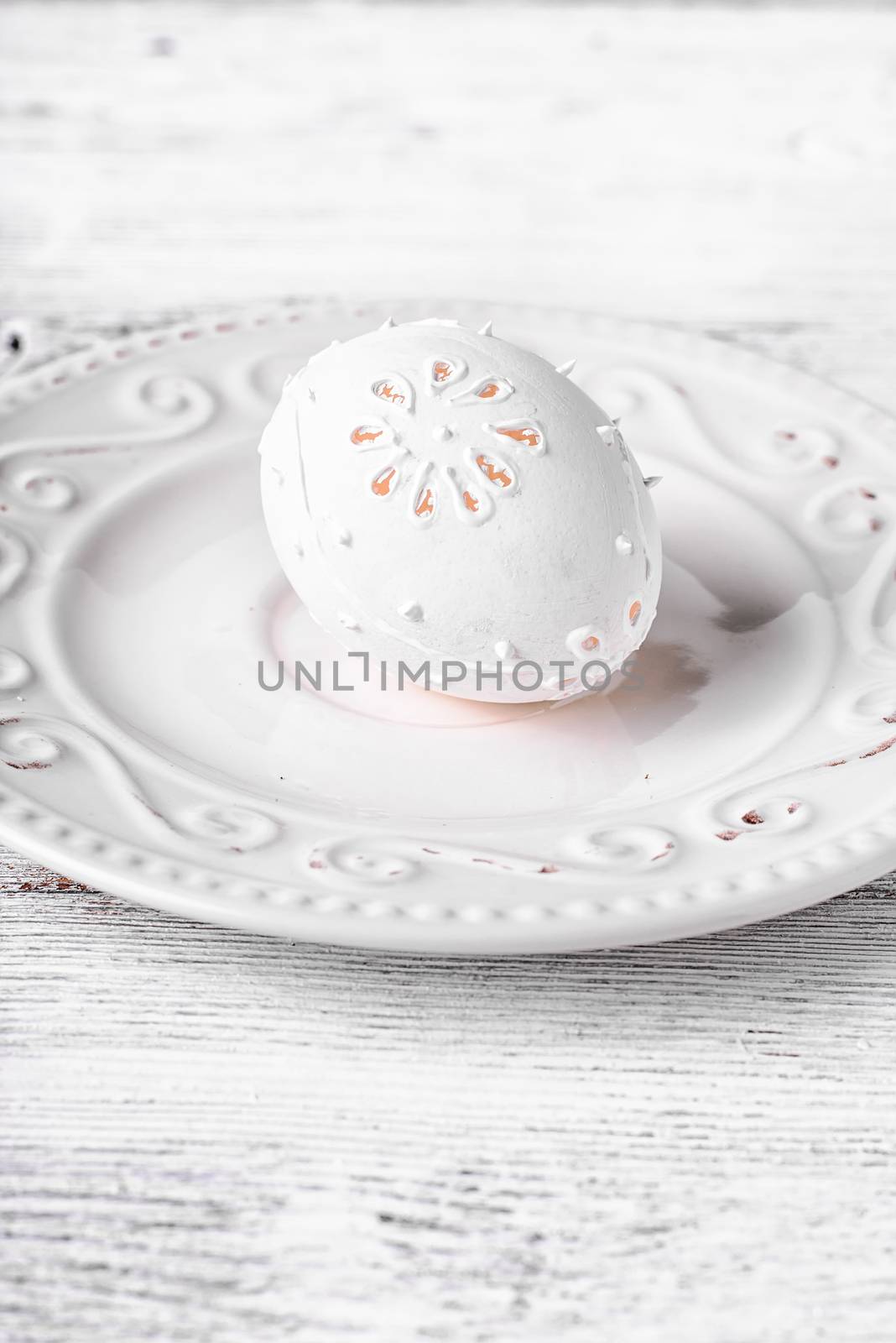 Decorative carved chicken egg for Easter to light the plate.Photograph high key.