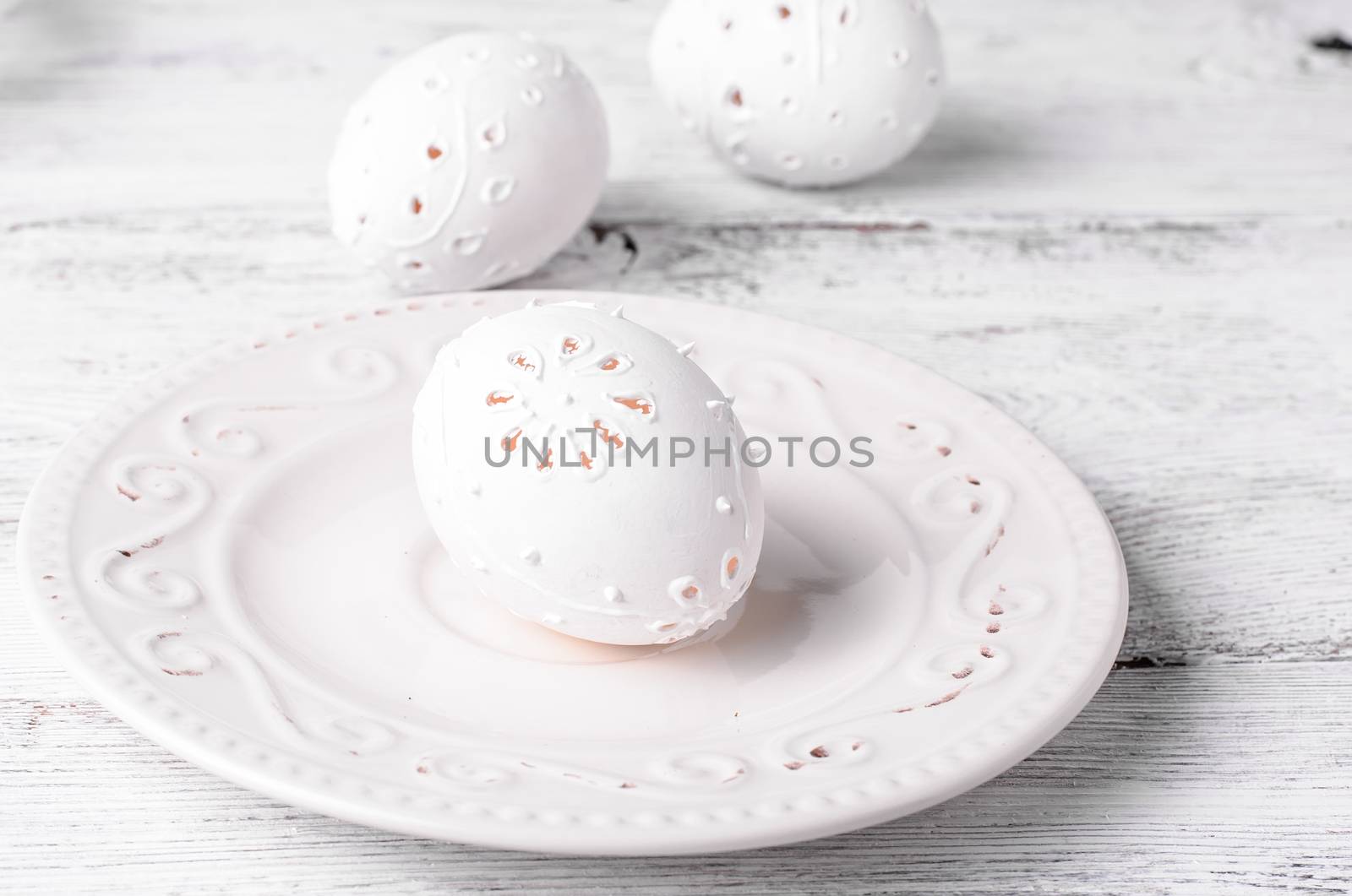 Easter eggs with cut out pattern by hand on light background.The photograph high key.