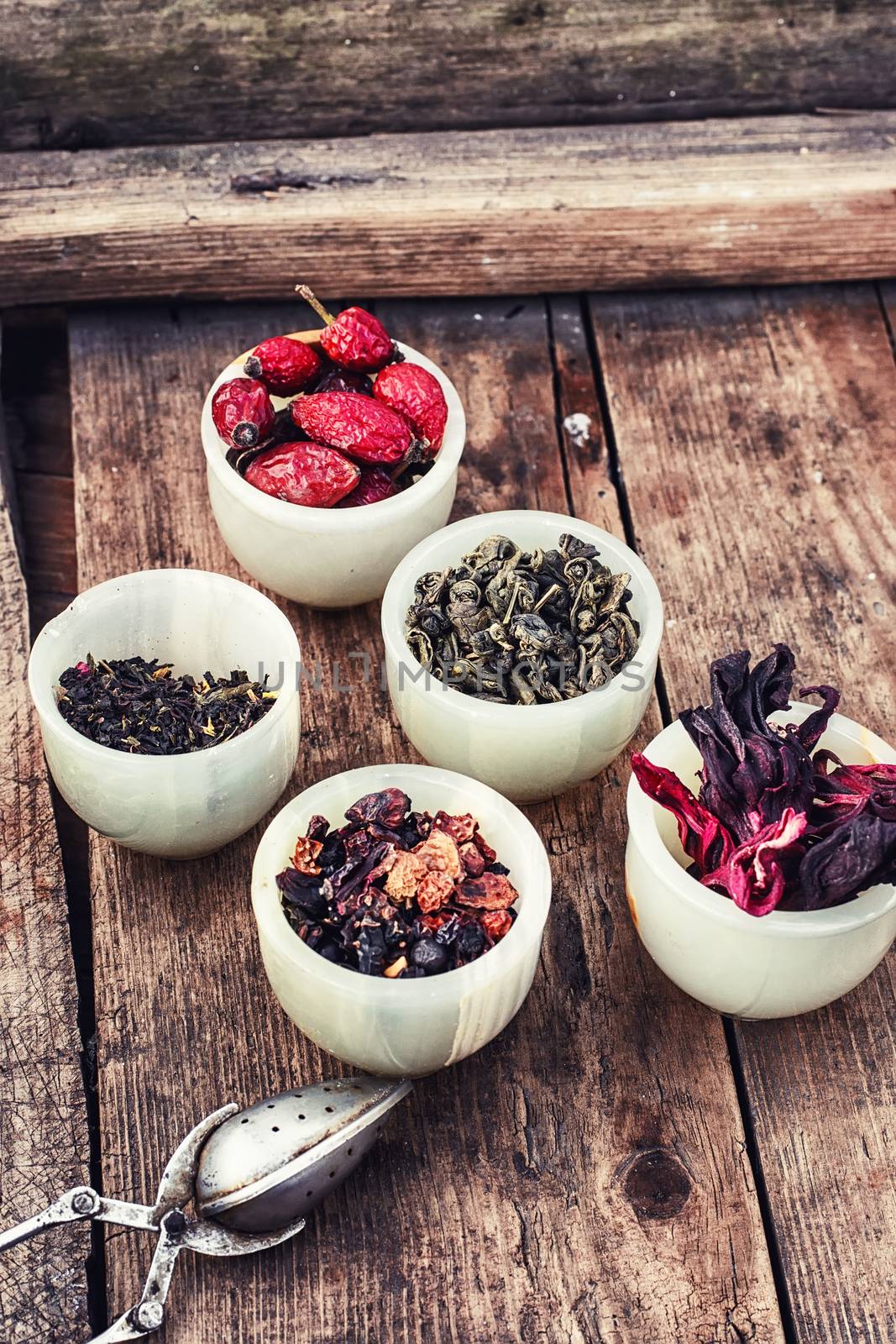 Tea leaves of different varieties in the stacks of custard and spoon