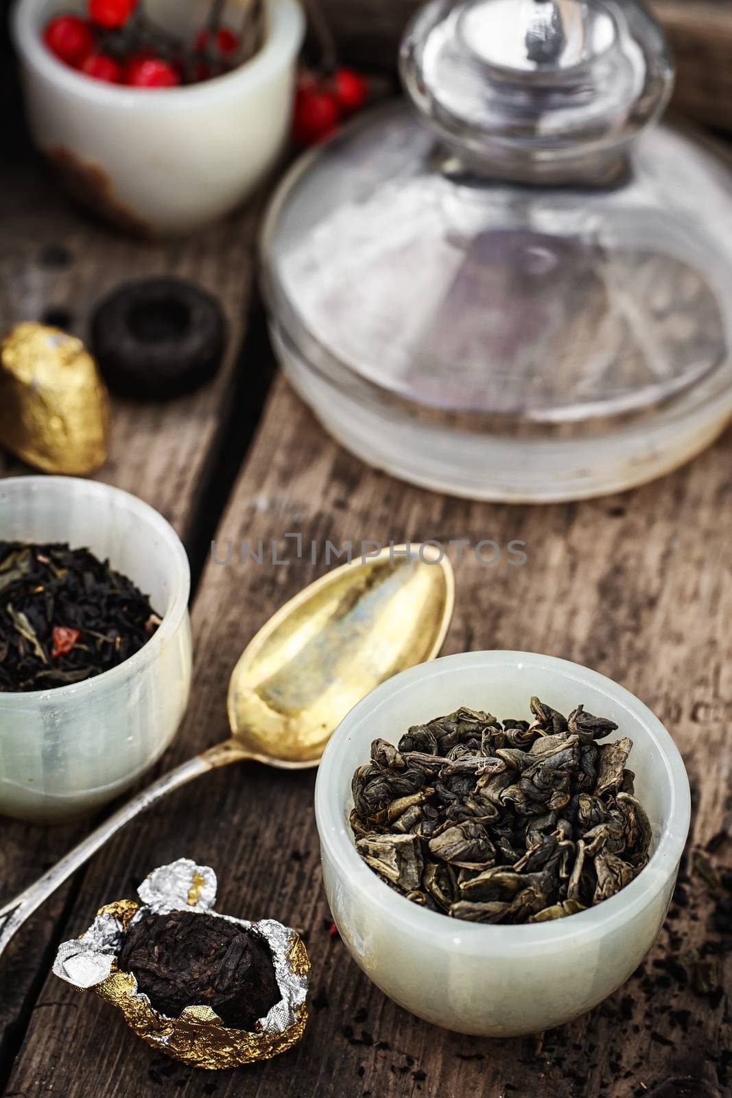 Tea leaves of different varieties in the stacks of custard and spoon