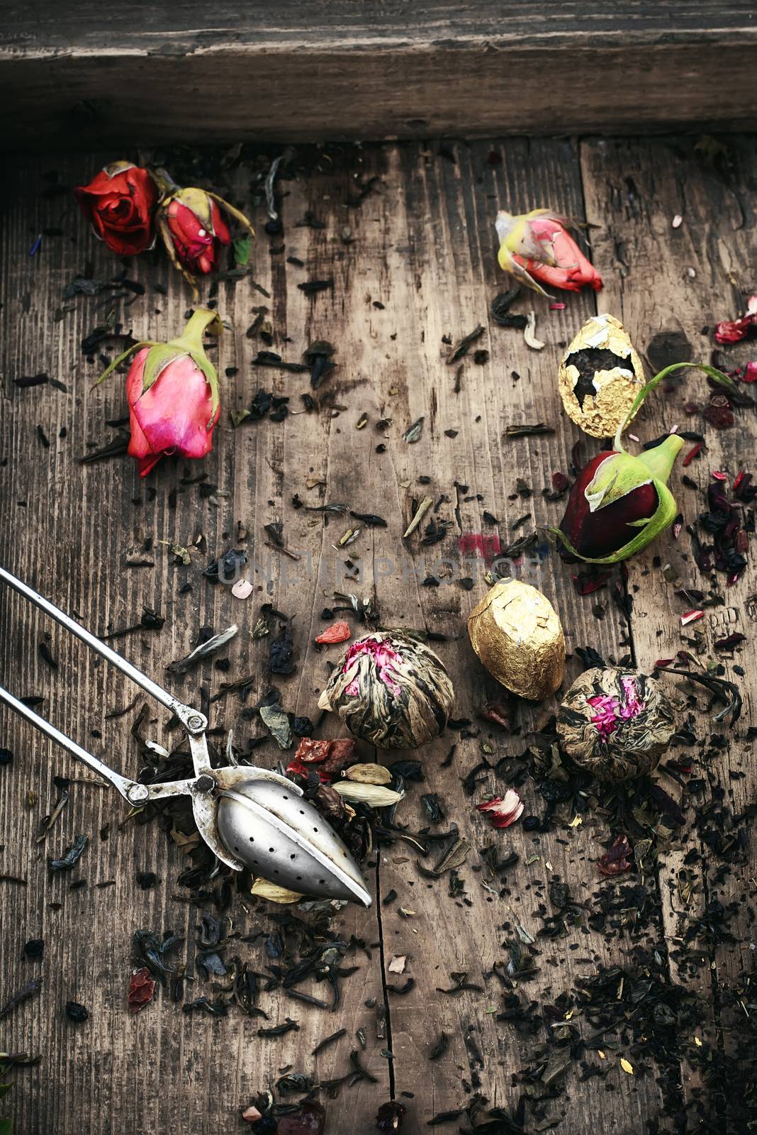 Spoon and spilling the tea leaves of different varieties on retro background