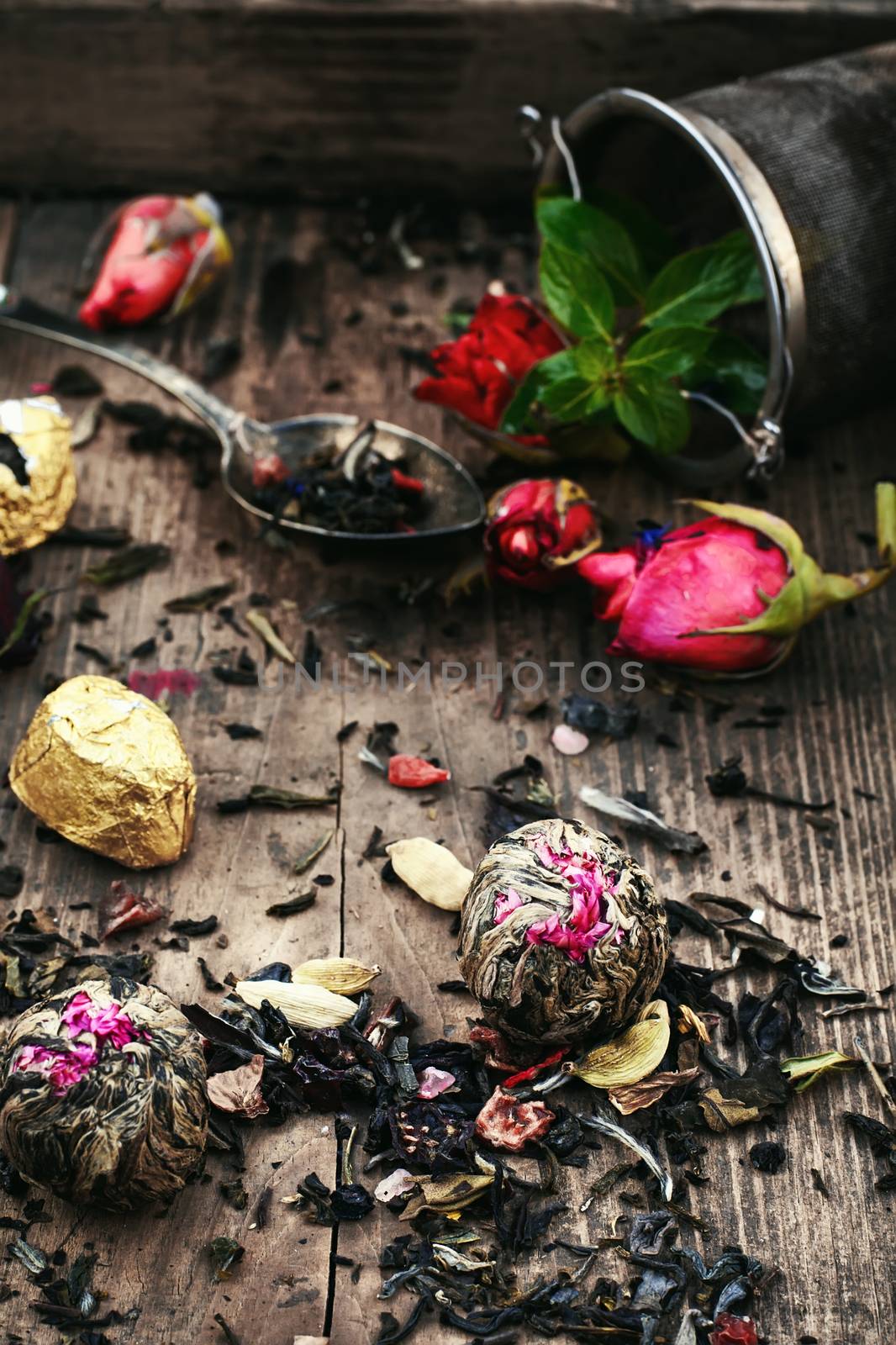 Spoon and spilling the tea leaves of different varieties on retro background