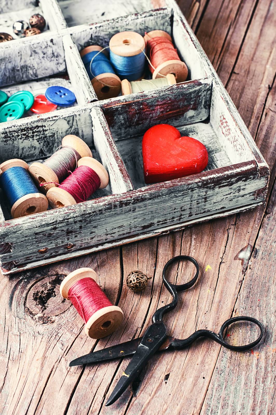 Wooden box with reels of sewing threads and buttons