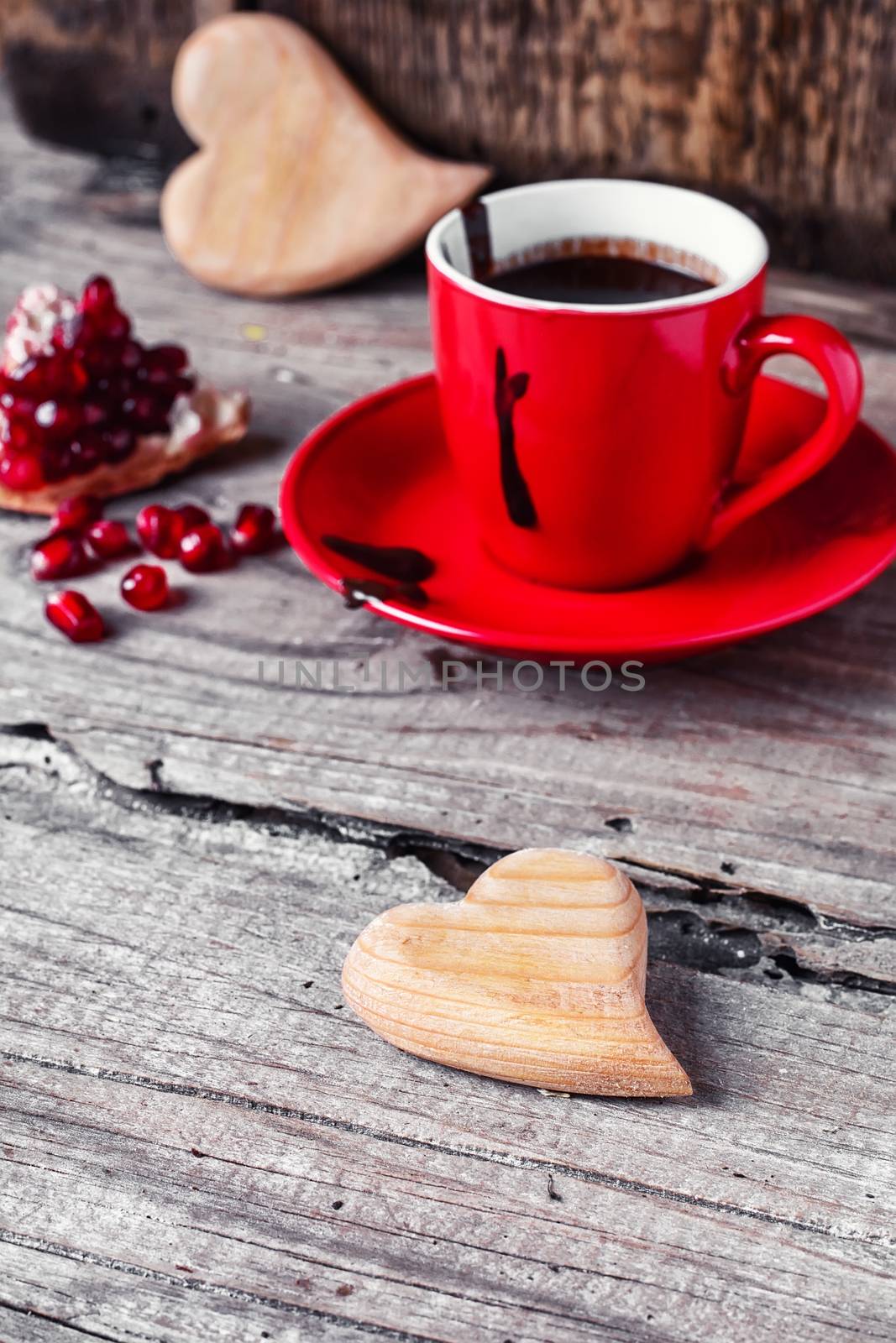 Hot chocolate in the cup on the saucer and broken pomegranate