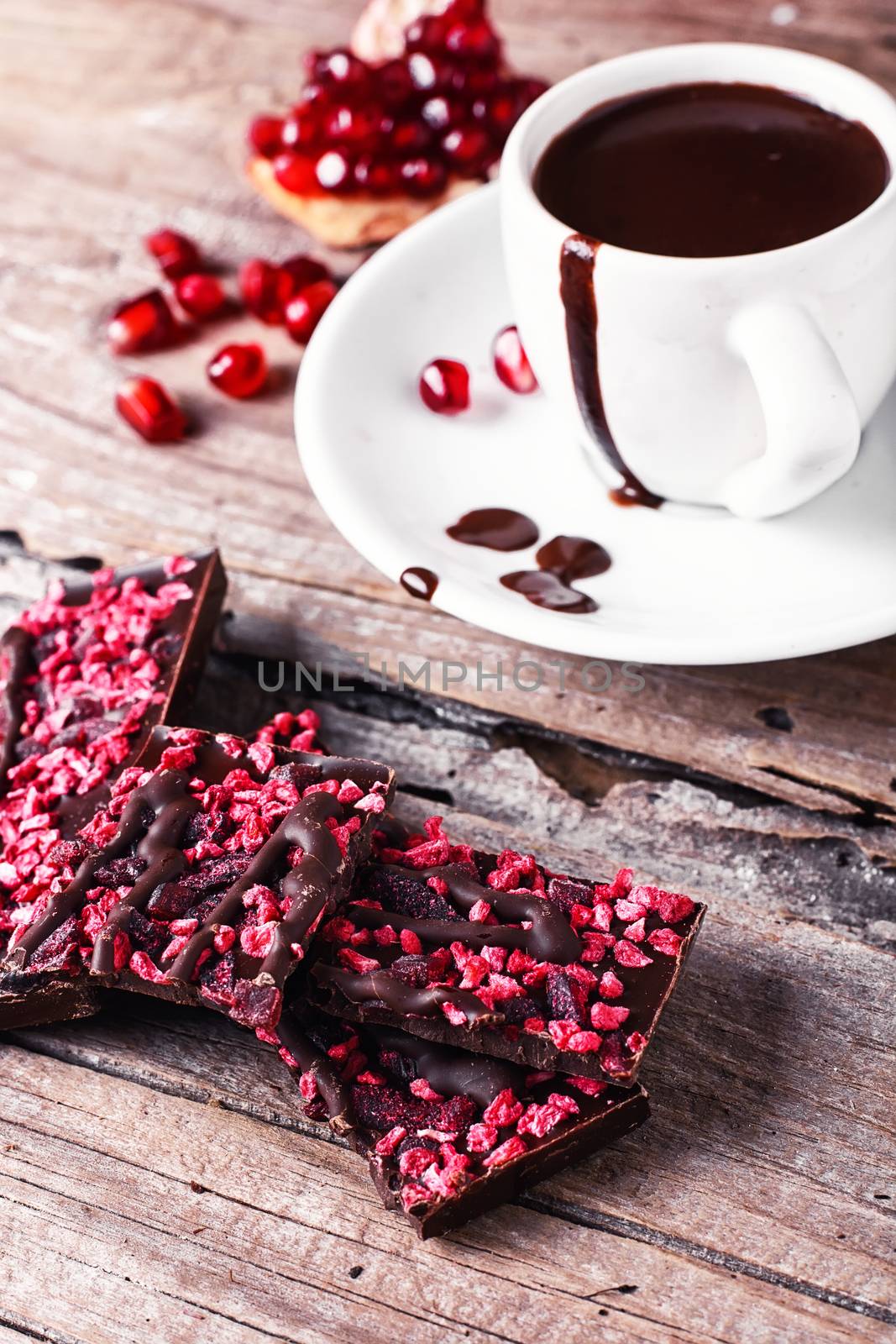 Hot chocolate in the cup on the saucer and broken fruit chocolate