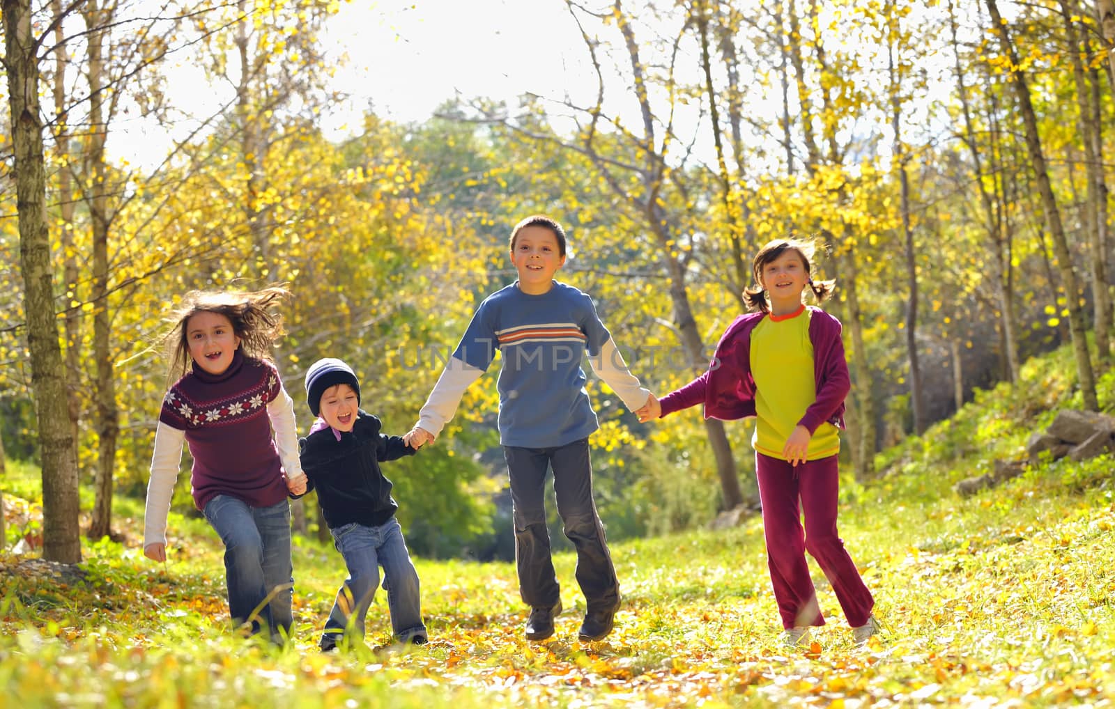  friends boys and girls running in the park 