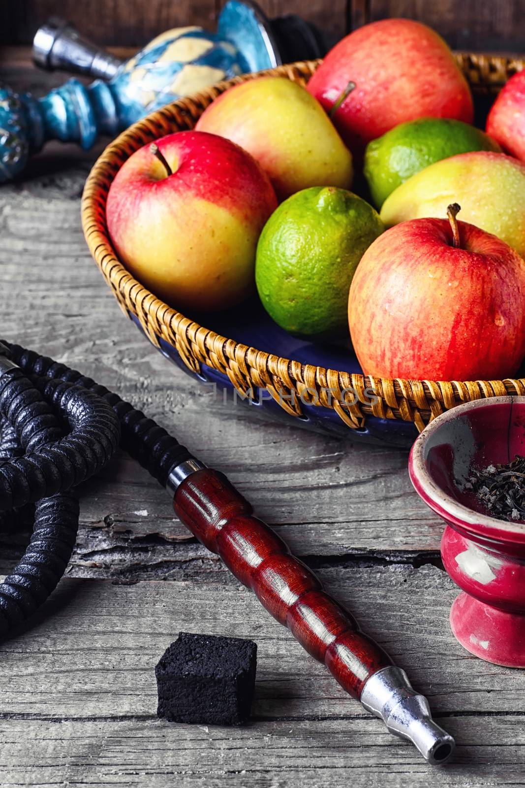 Smoking hookah and basket with apples,pomegranate and lime