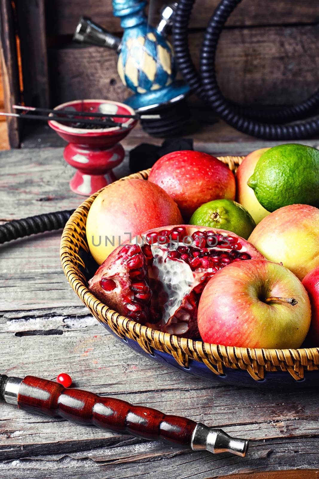 Smoking hookah and basket with apples,pomegranate and lime