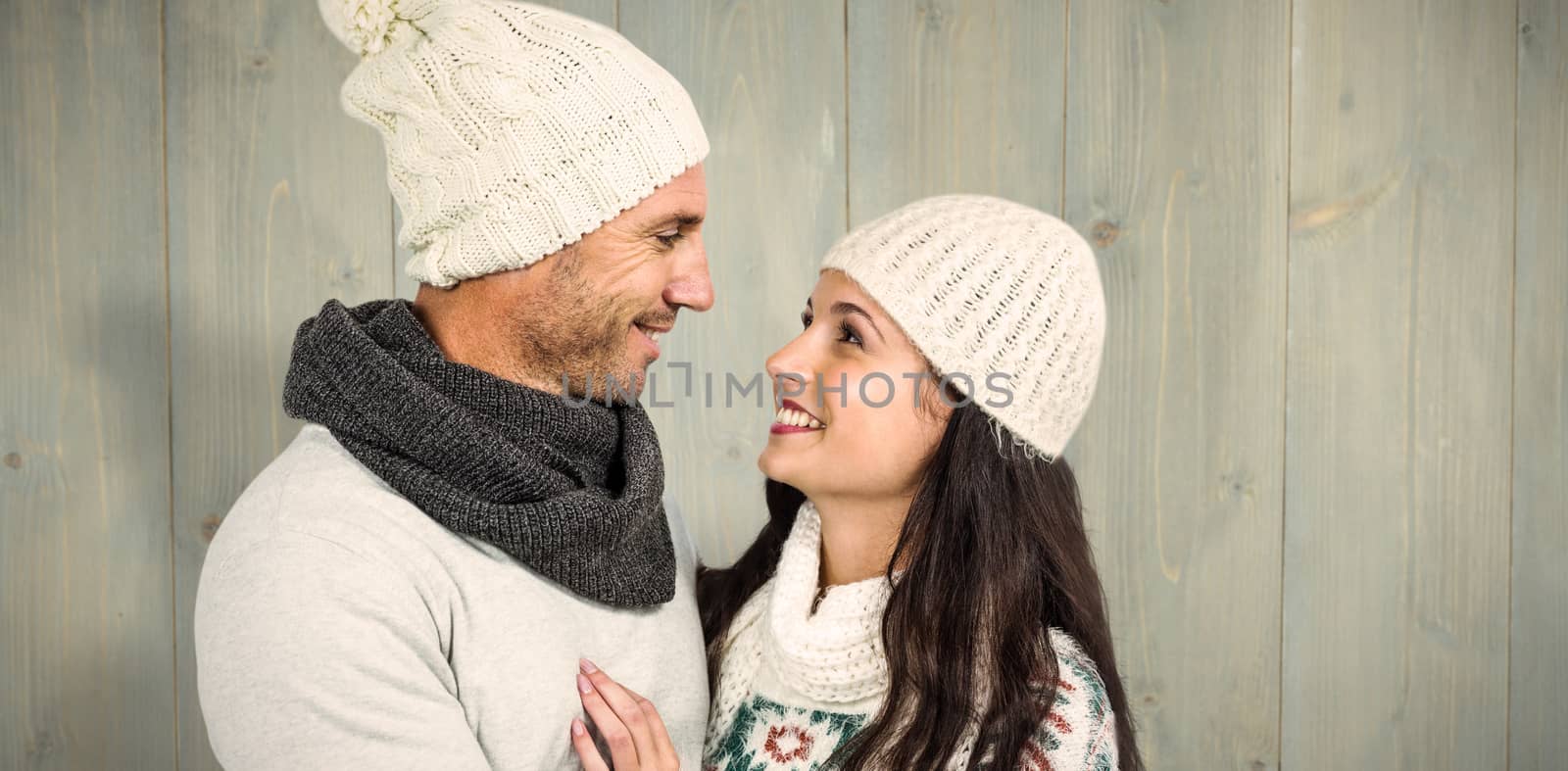Smiling couple looking at each other against wooden planks