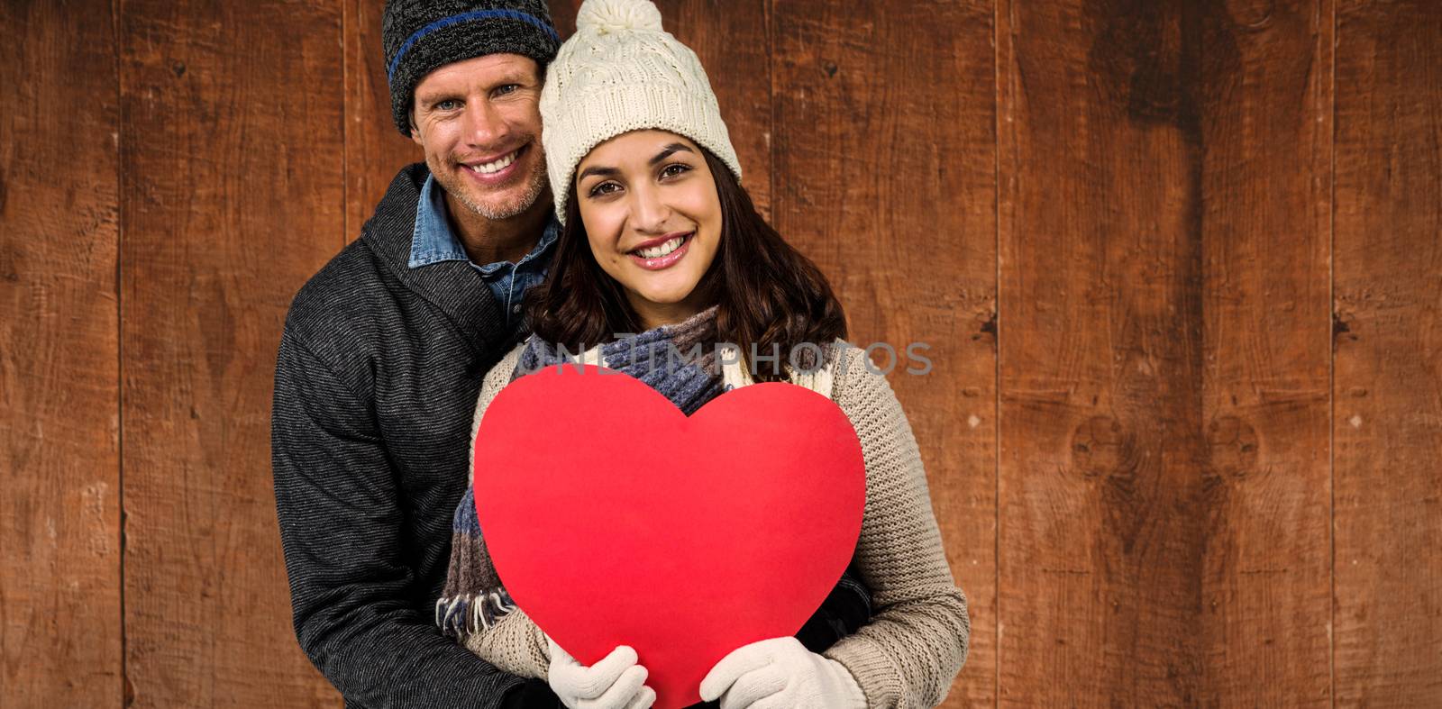 Composite image of festive couple in winter clothes  by Wavebreakmedia