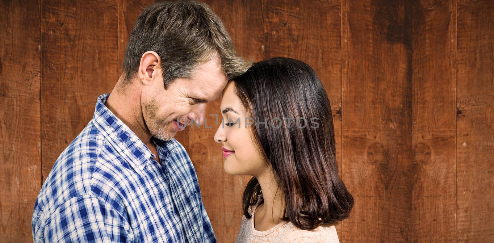 Close-up of romantic couple standing face to face against weathered oak floor boards background