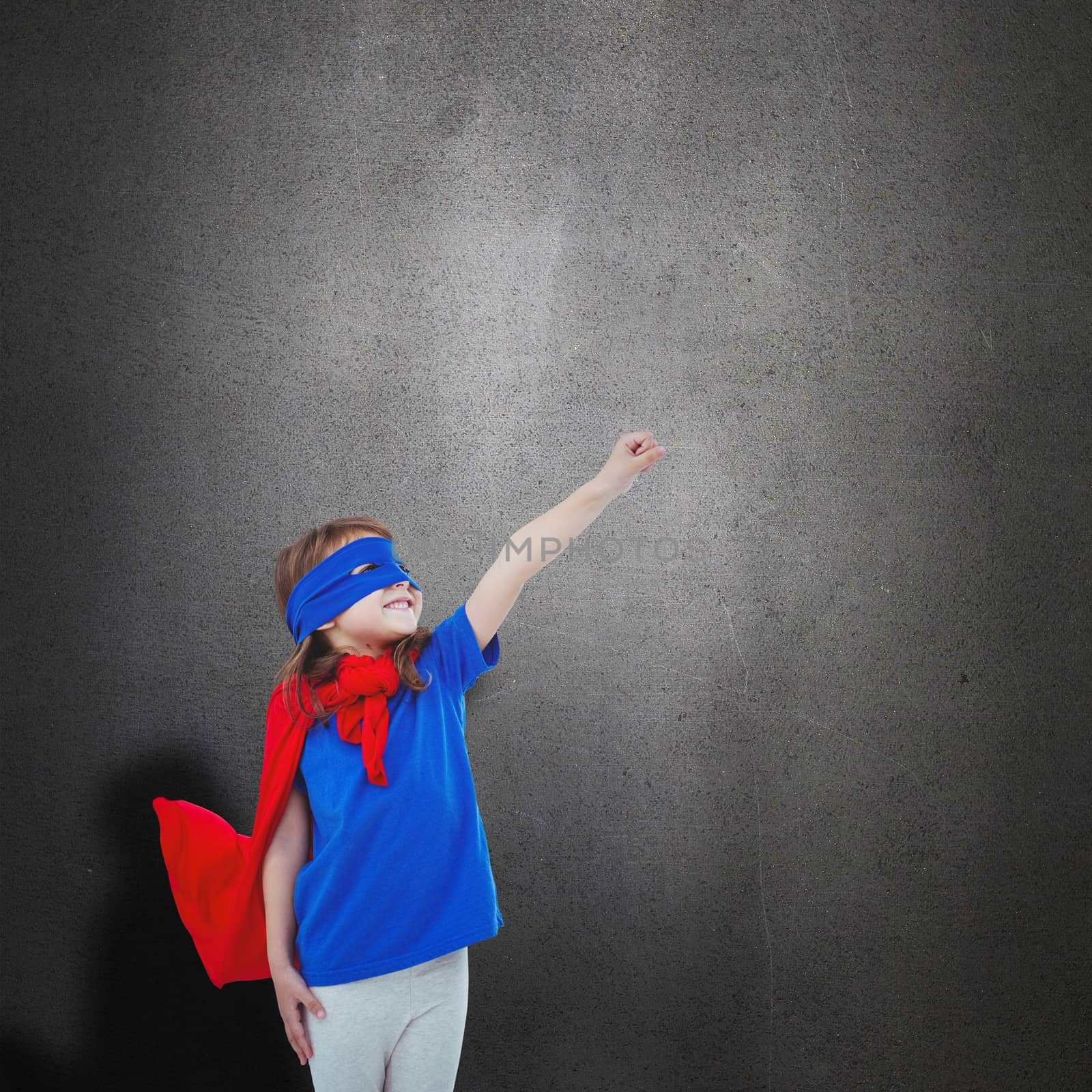Masked girl pretending to be superhero against grey room