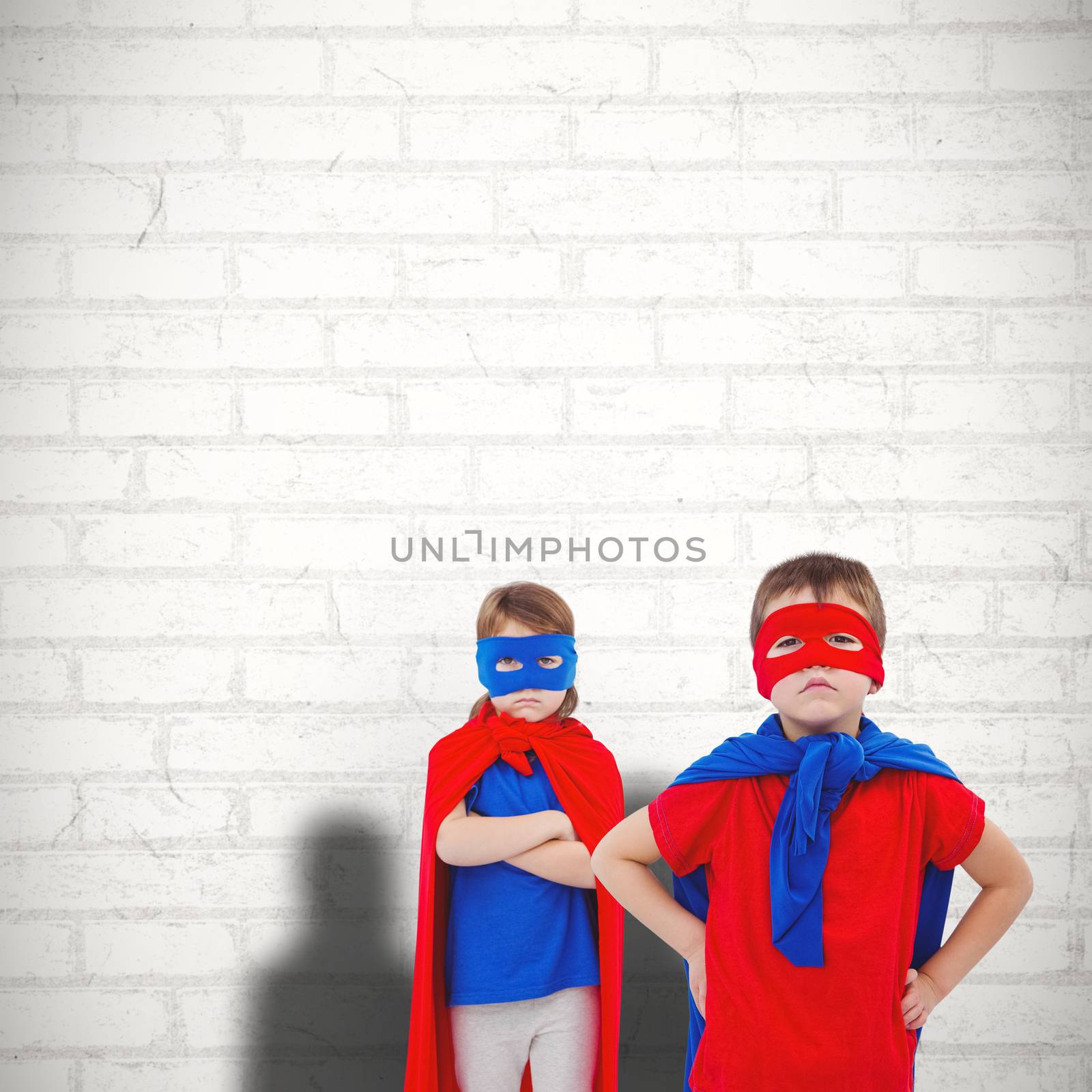 Masked kids pretending to be superheroes against white wall