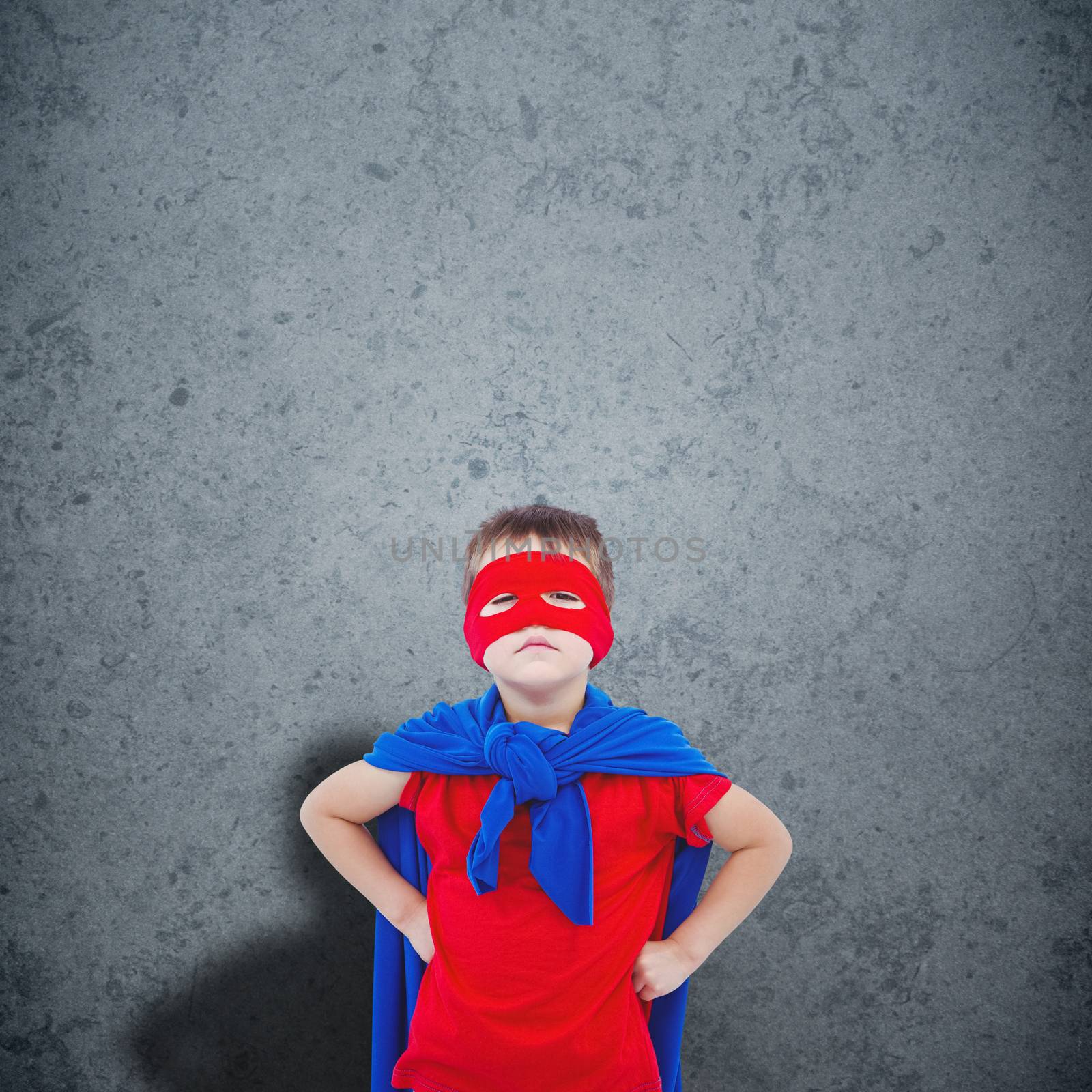 Masked boy pretending to be superhero against dirty old wall background