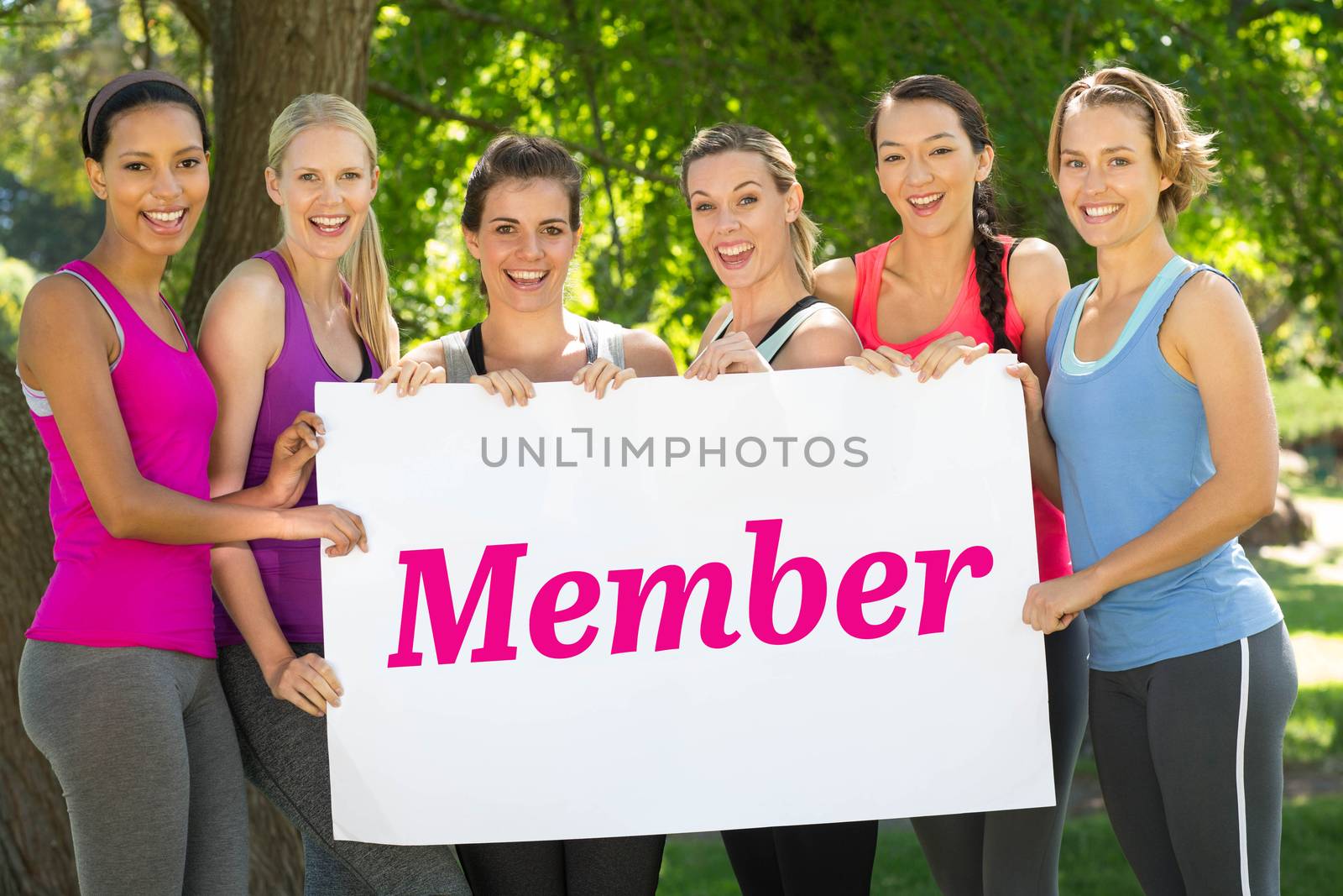 The word member and white wall against fitness group holding poster in park