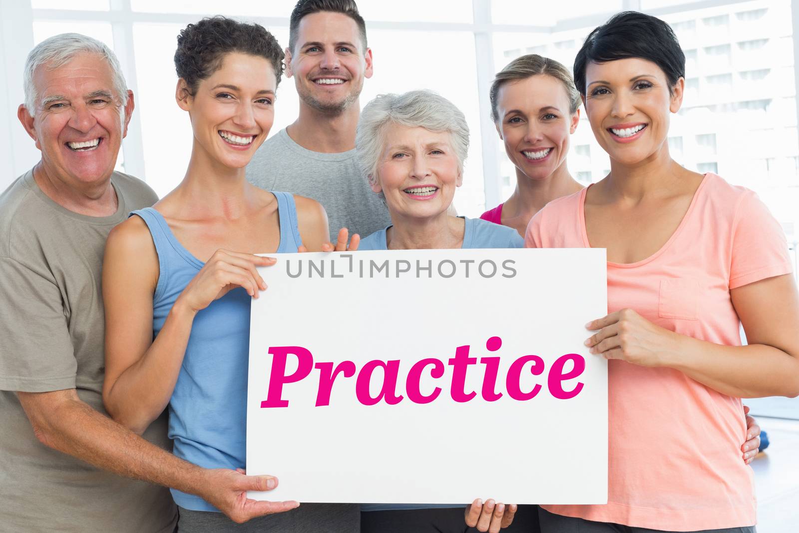 The word practice and fit people holding blank board in yoga class against room with wooden floor