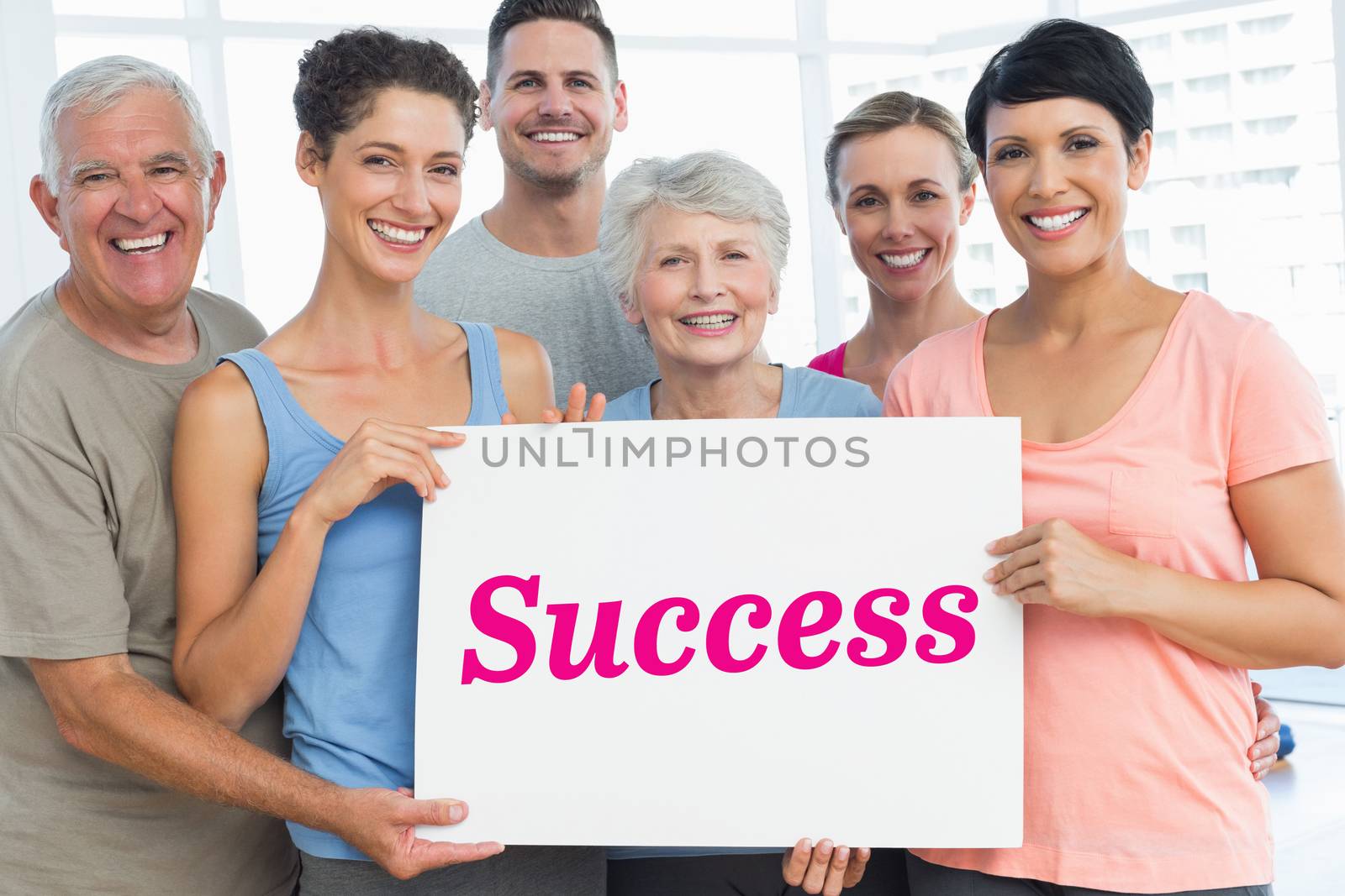 The word success and fit people holding blank board in yoga class against white angular design