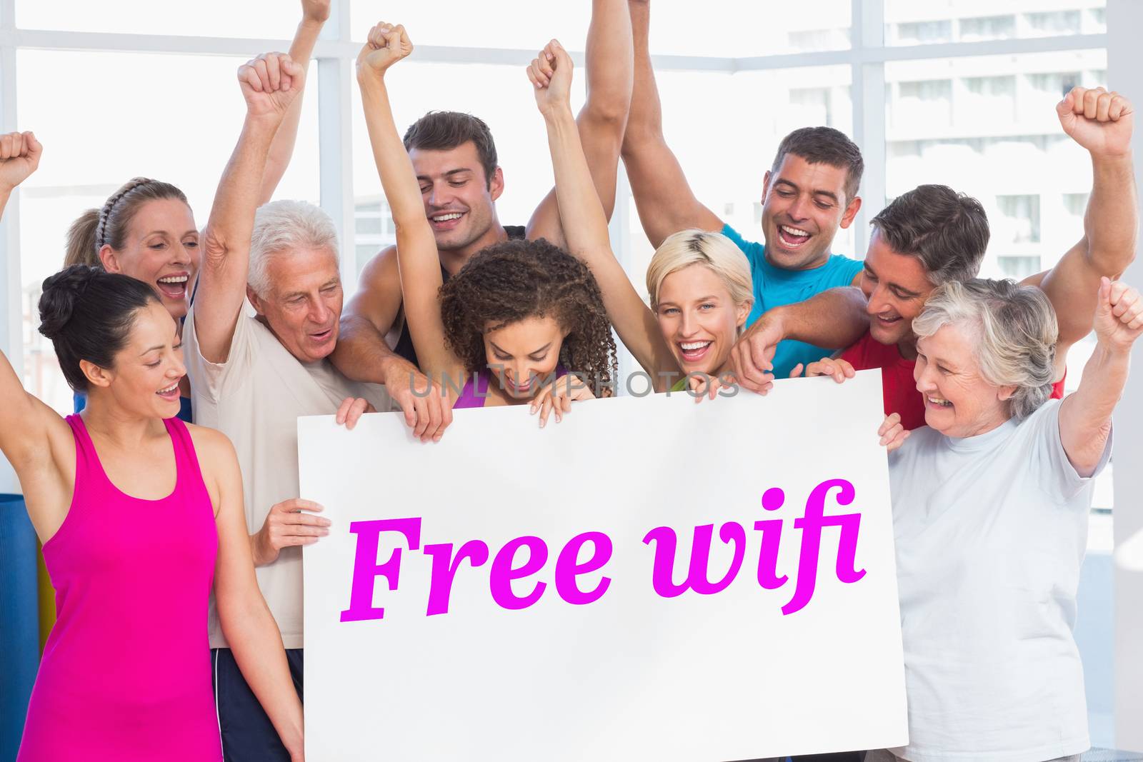 The word free wifi and excited people holding blank billboard at gym against grey wall
