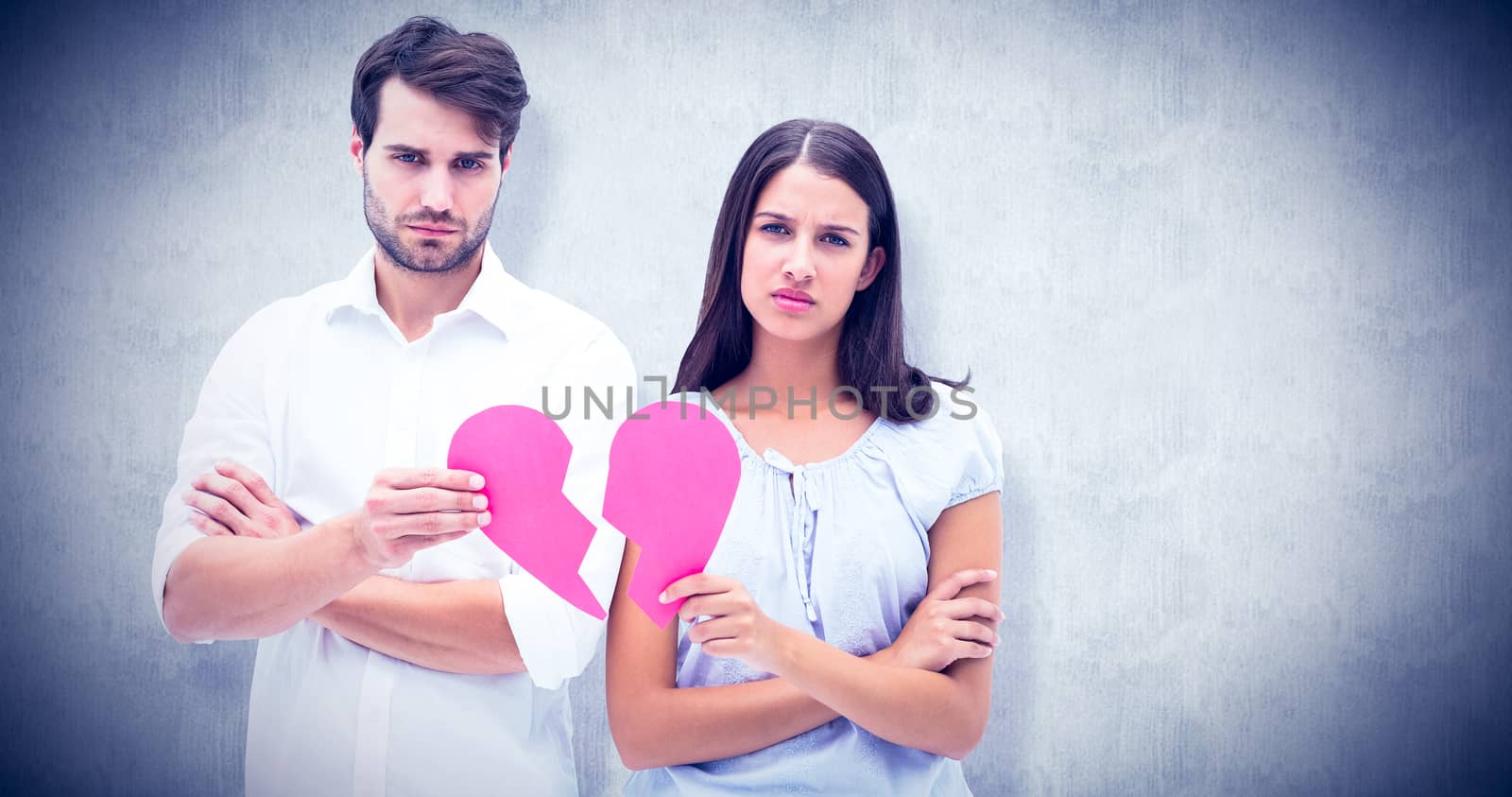 Upset couple holding two halves of broken heart against white background