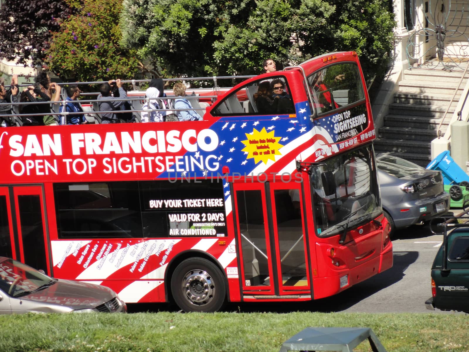 SAN FRANCISCO, USA - JULY 22 2010: Red Tour bus (San Francisco Open Top Sightseeing) in front of Victorian houses on Alamo Square in San Francisco, CA. Double Decker CityBus Tour