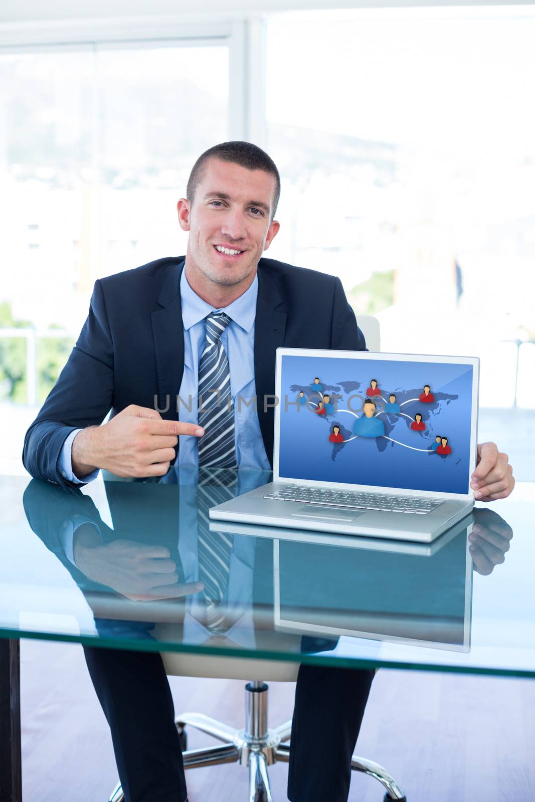 Smiling businessman pointing at laptop screen in office against communication between people from various continents
