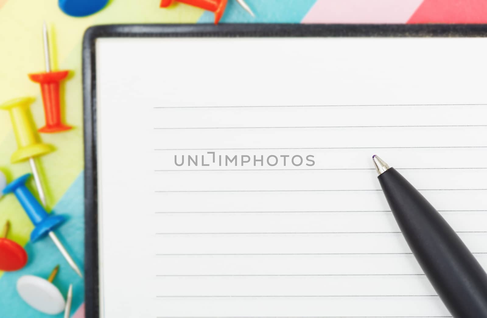 Notepad with pen and pushpins. Close-up photo