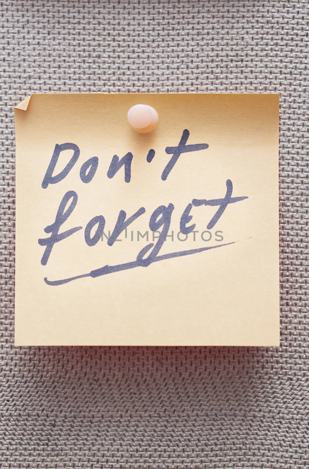 Adhesive note with Do not forget text on a bulletin board