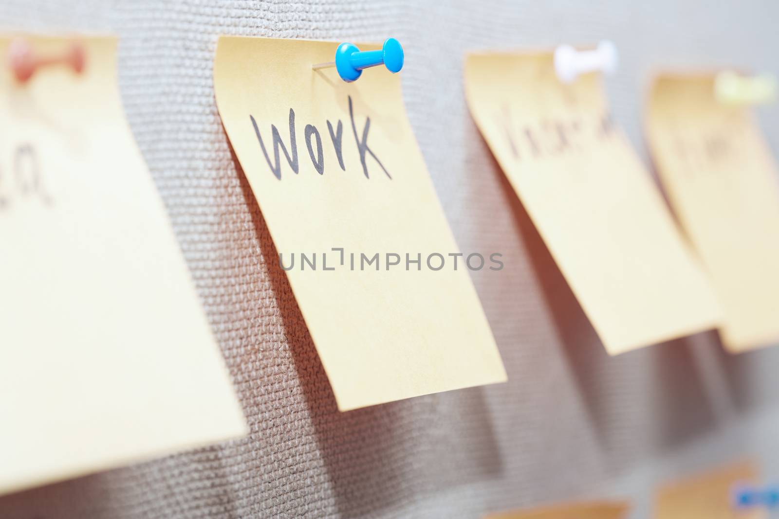 Adhesive note with Work text on a bulletin board