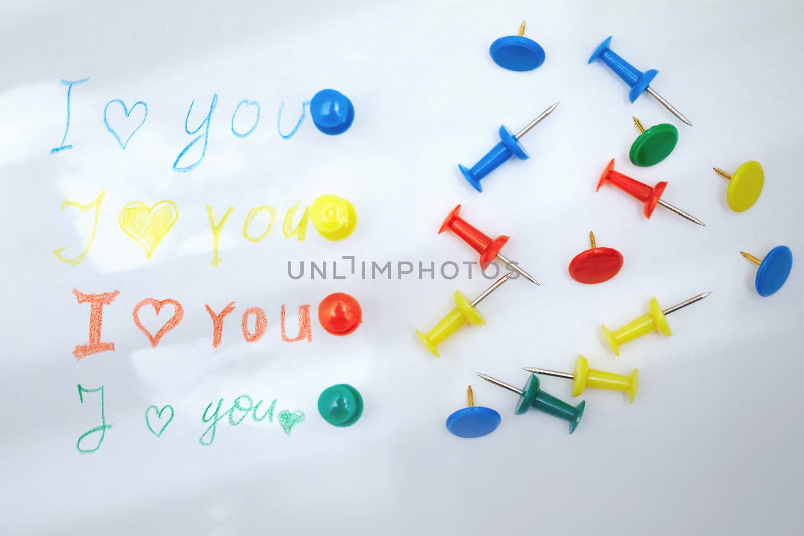 Love you letter with colorful push pins. Sunlight shadows and flare