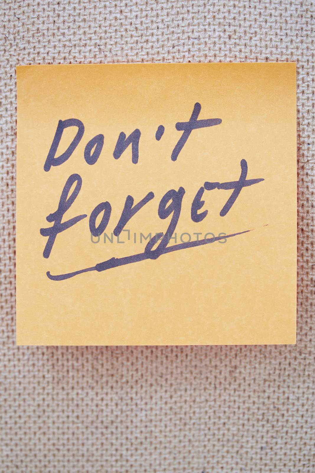 Adhesive note with Do not forget text on a bulletin board