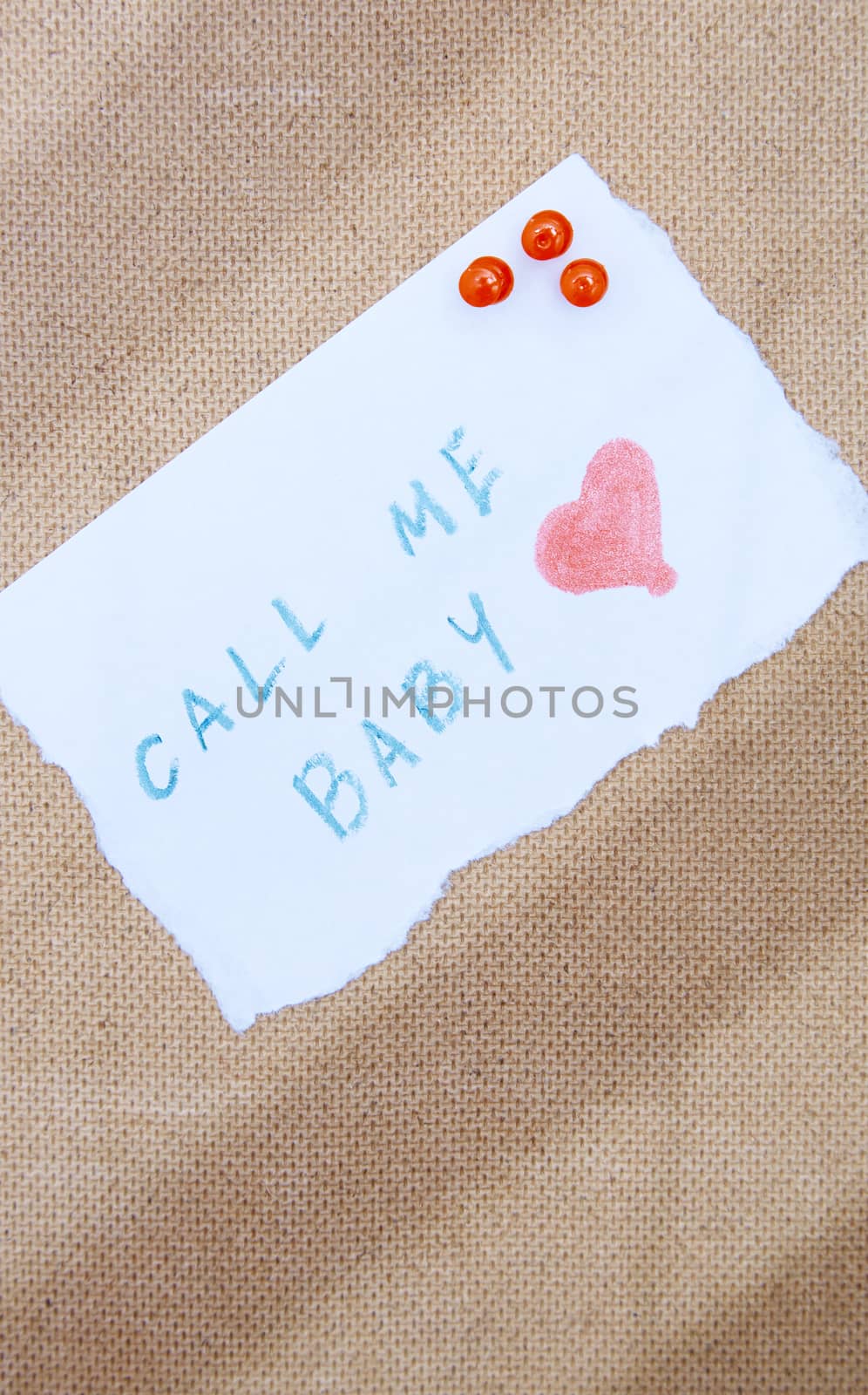 Call me written on a paper attached by pushpins to the wooden bulletin board