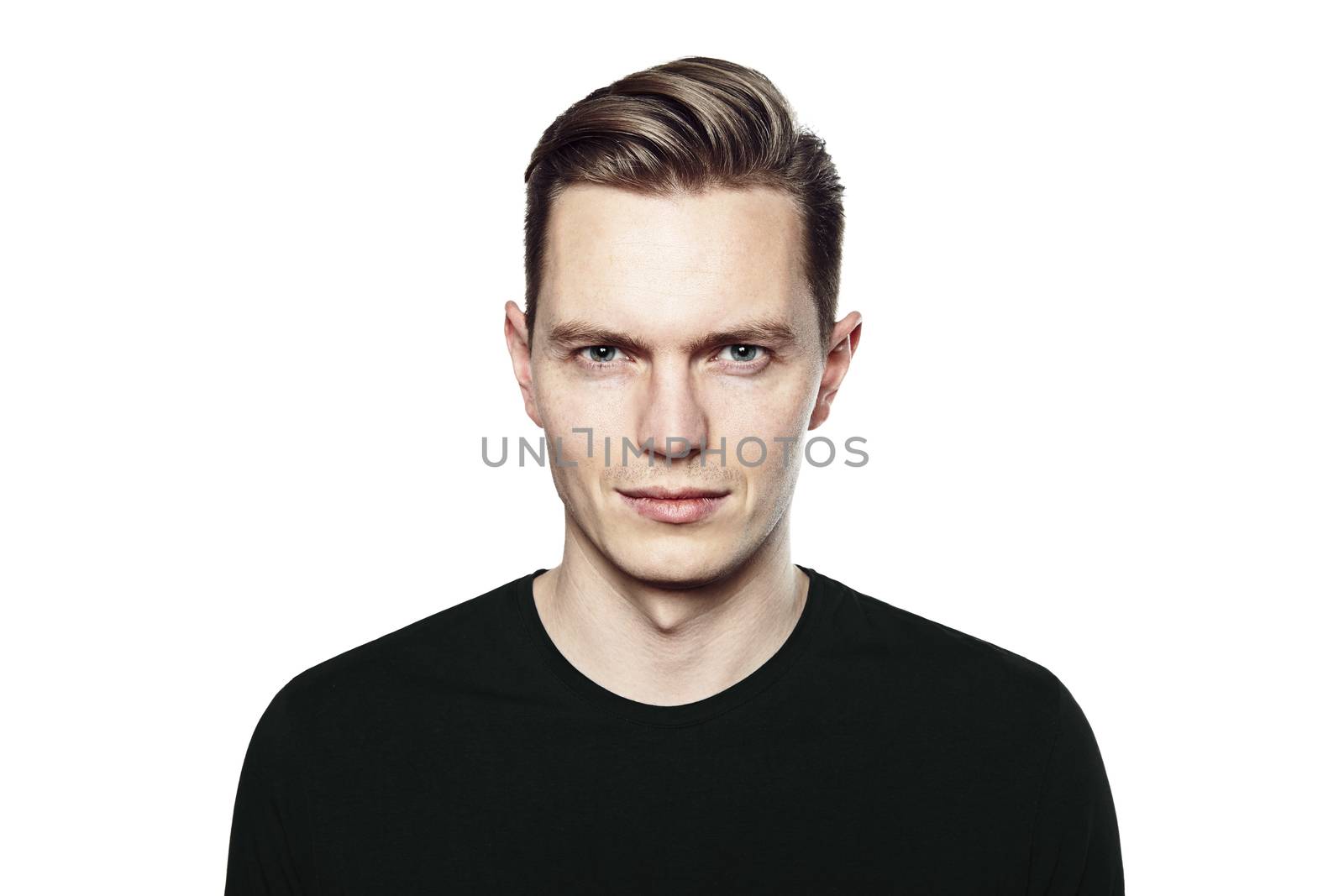 Studio shot of young handsome man. He is looking to the camera, he is wearing a black T-shirt.