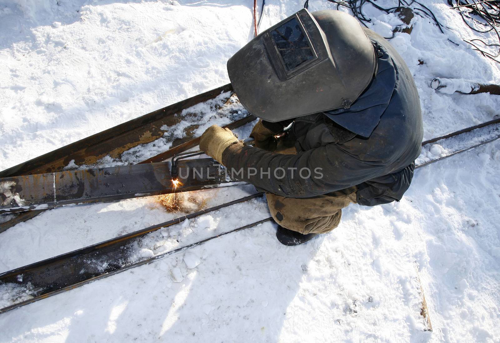 Industrial worker uses an acetylene torch in winter outdoor