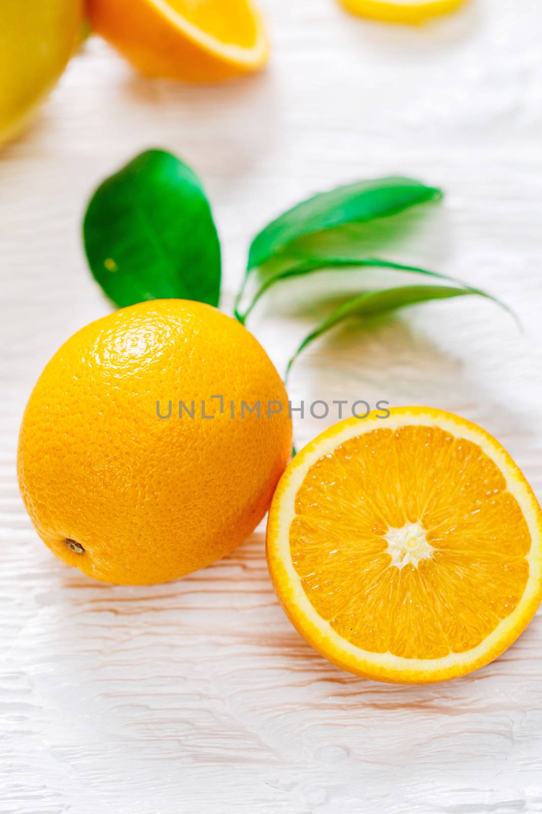 Oranges fruits composition with green leaves on a table 