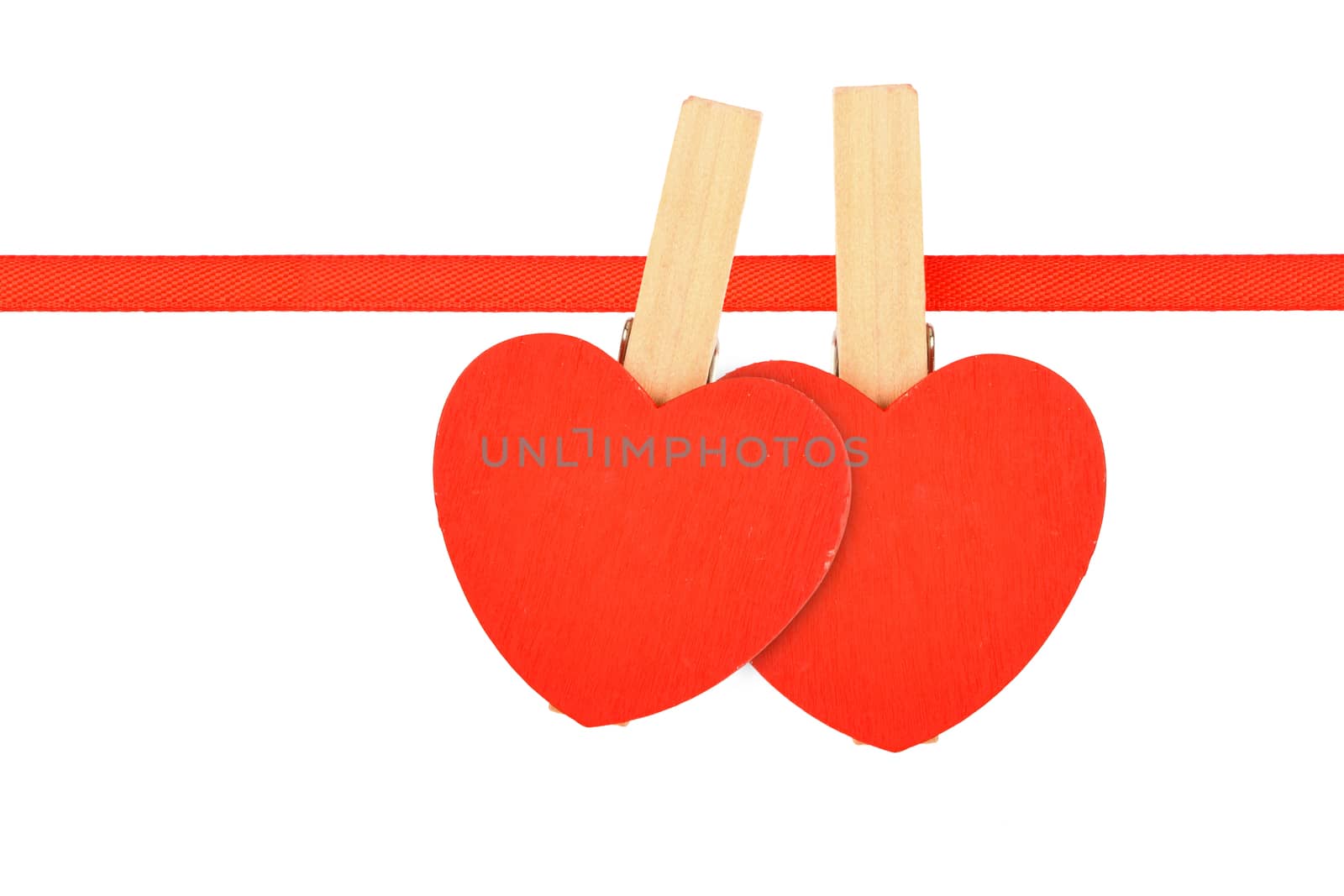 Valentine day love template, two red wooden hearts with clothes pins on textile ribbon isolated on white background