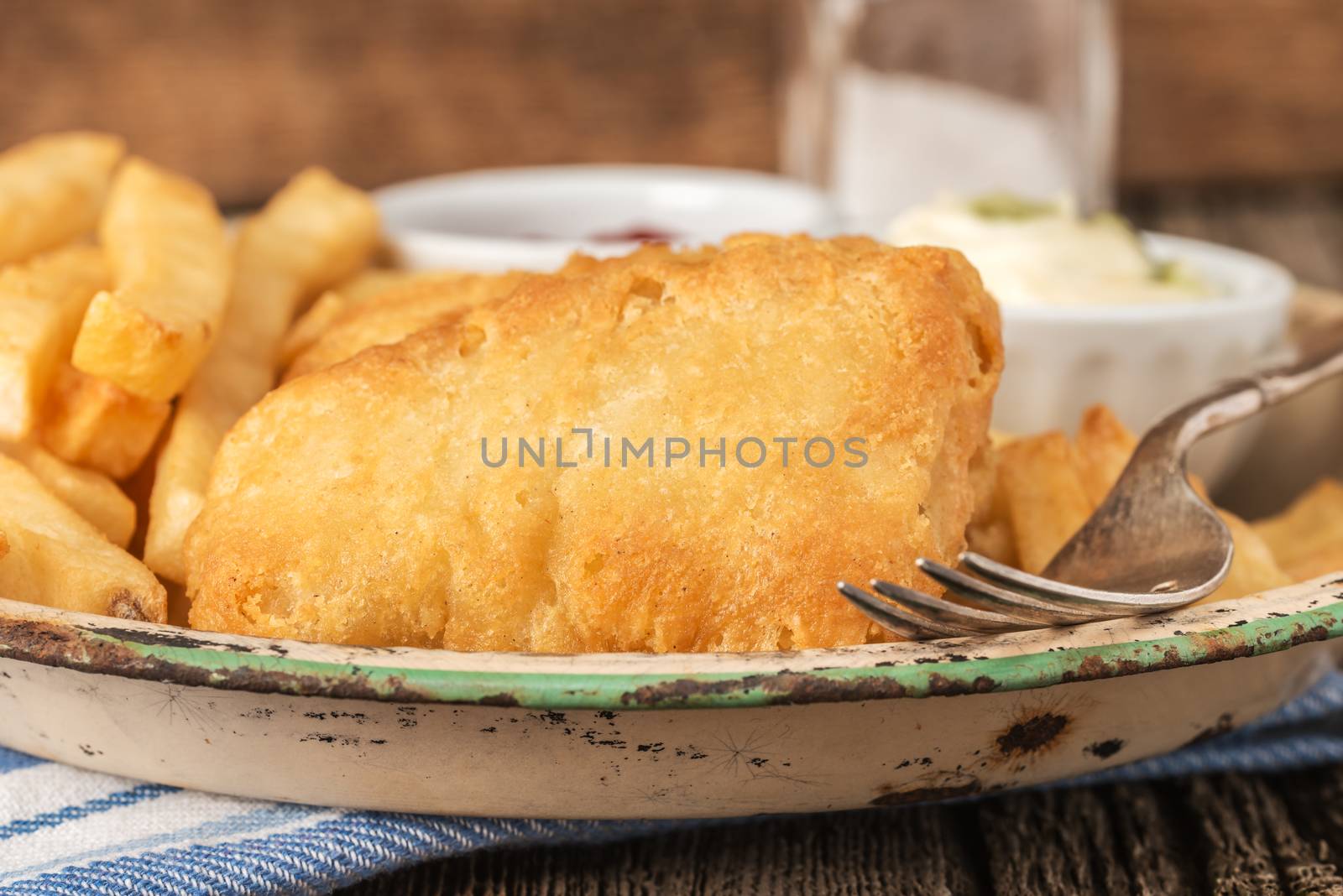 Battered fried haddock photographed closeup with a selective shallow depth of field.