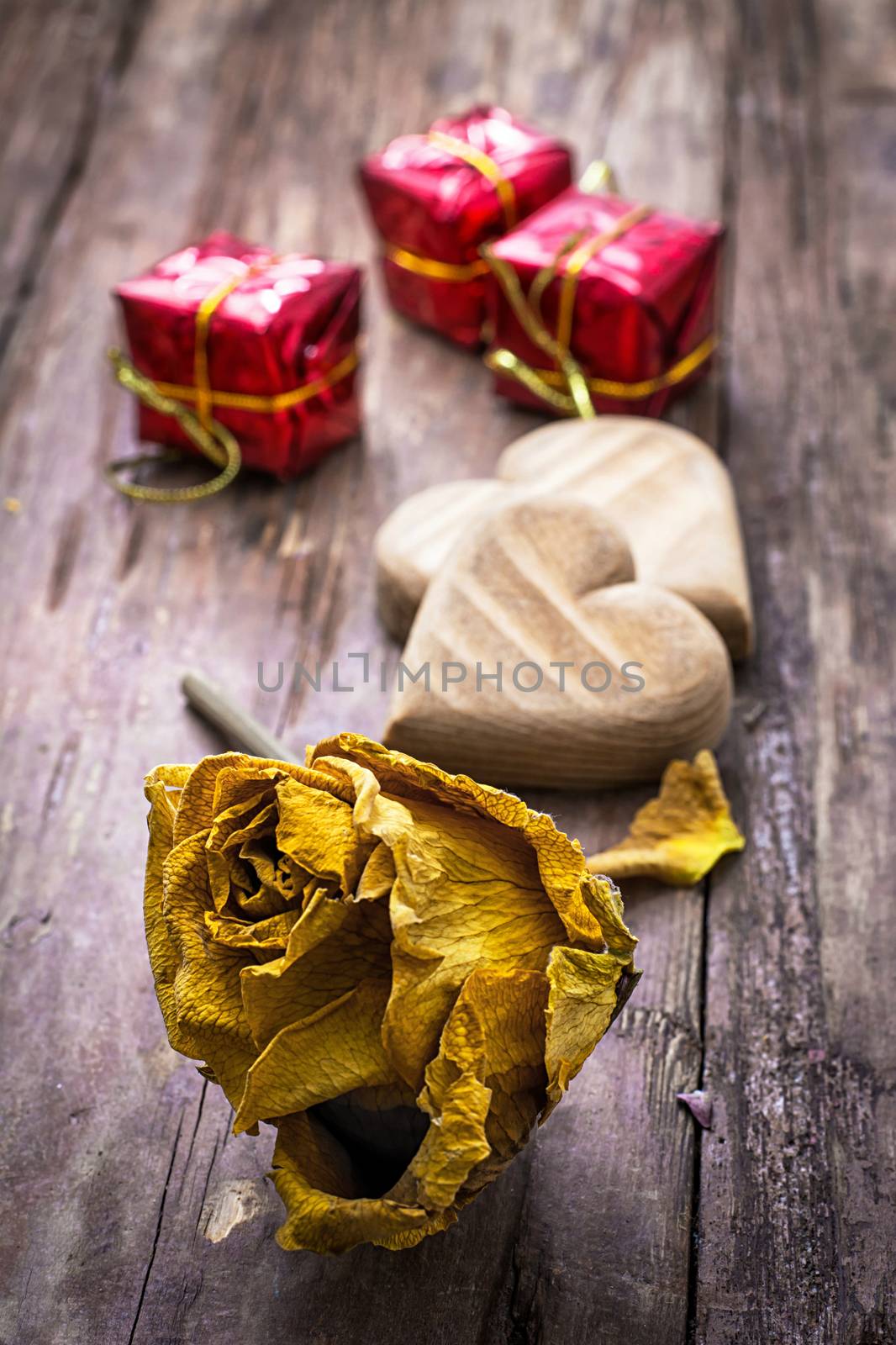 hand-carved symbolic wooden heart on a background of yellow roses