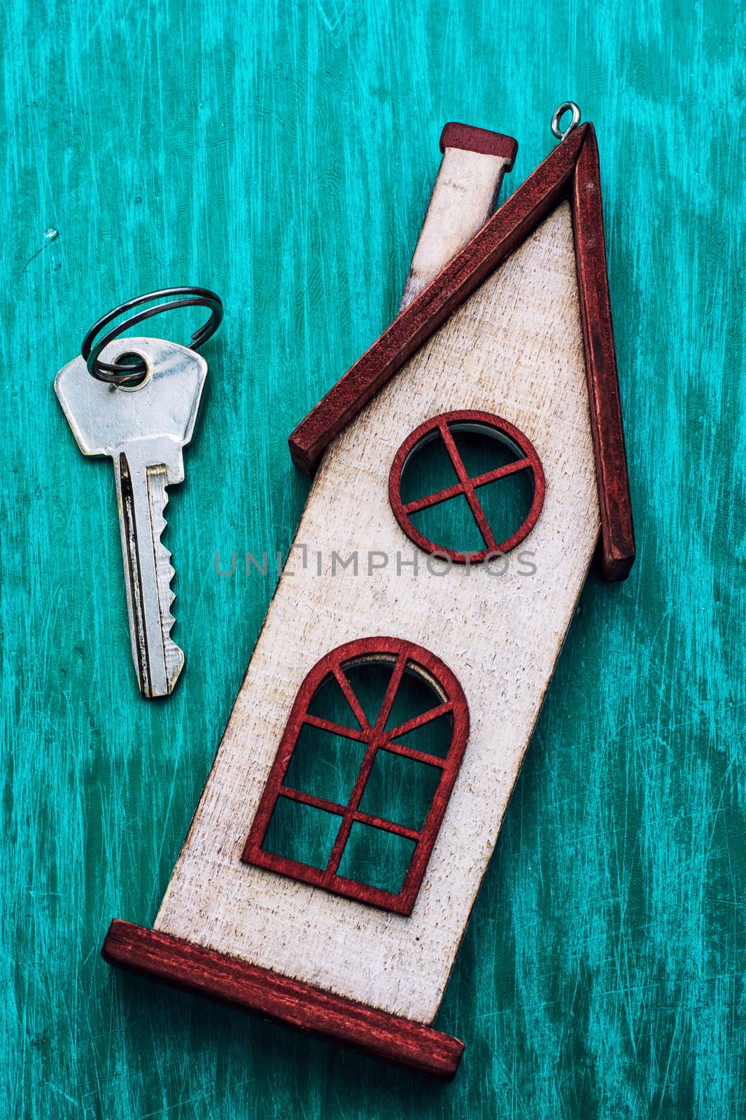symbolic house and key on wooden background turquoise