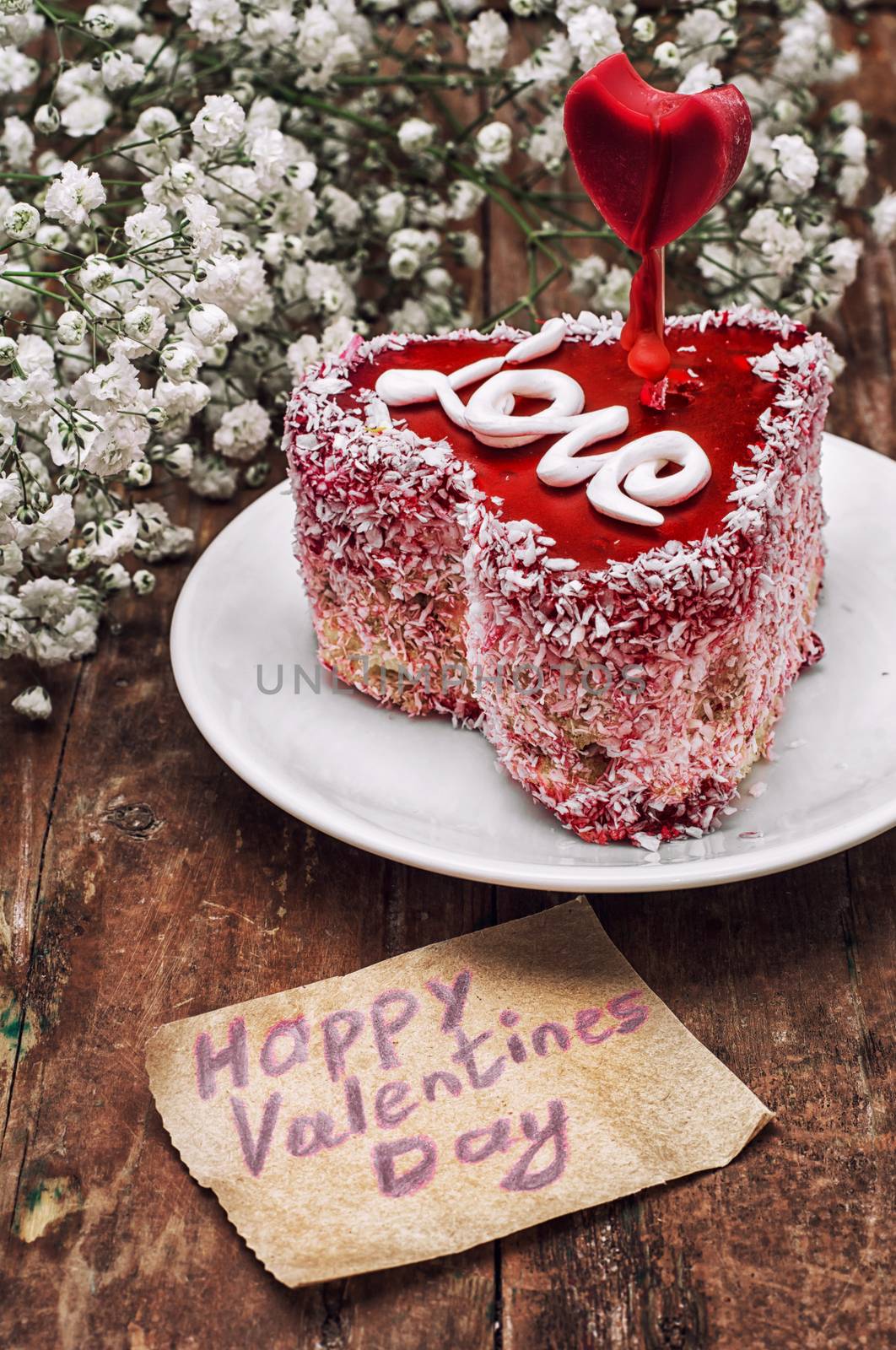 cake in the shape of heart with the inscription love and bunch of berries of viburnum