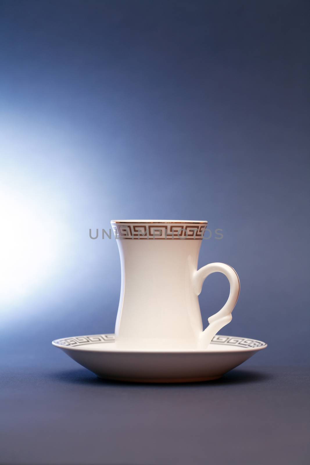 Stylish white coffee cup with saucer on dark background