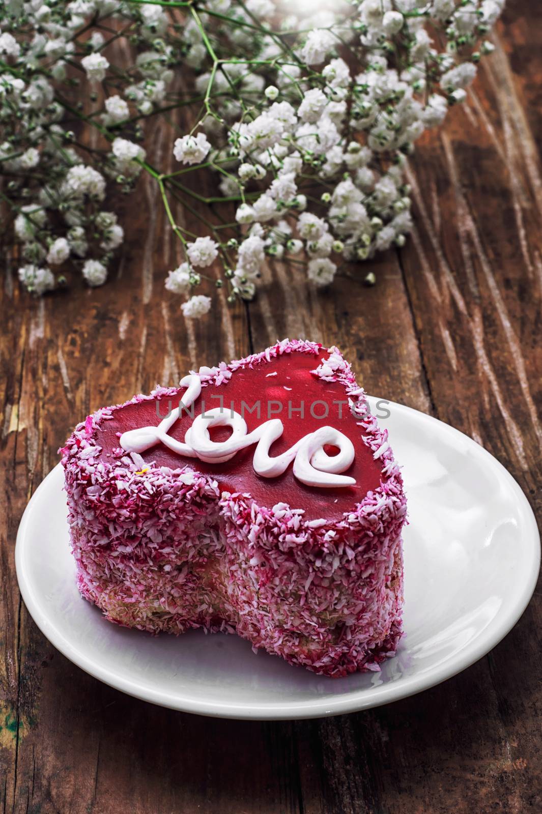 cake in the shape of heart with the inscription love and bunch of berries of viburnum