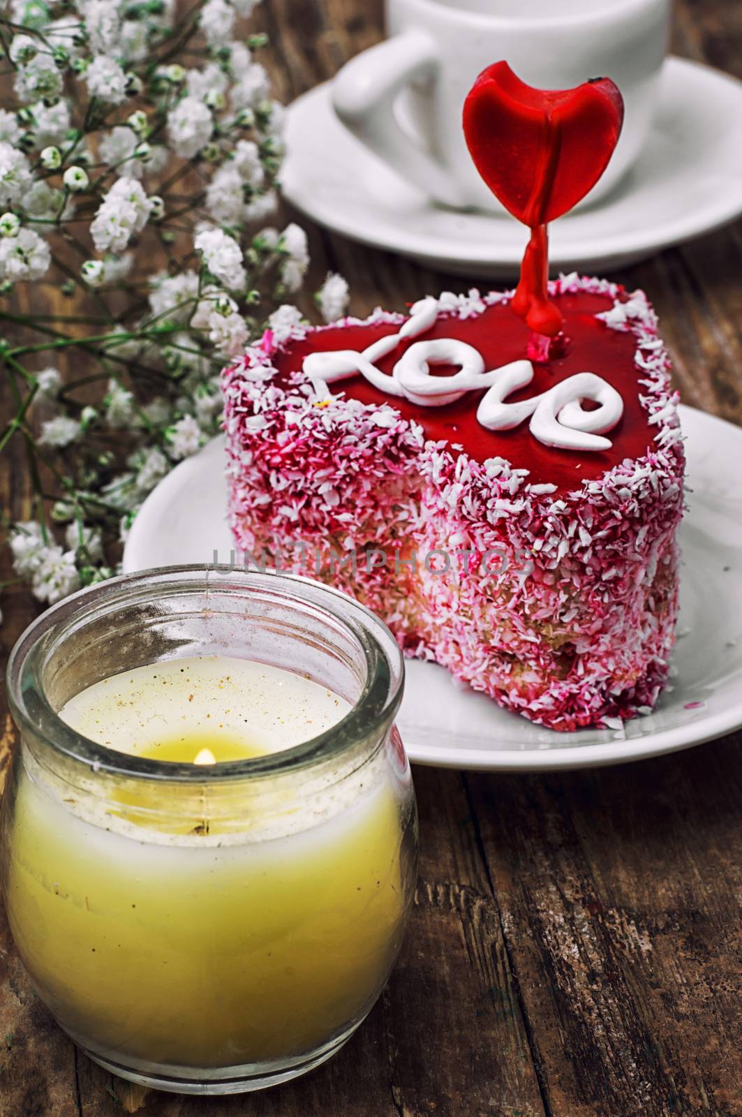 cake in the shape of heart with the inscription love and bunch of berries of viburnum