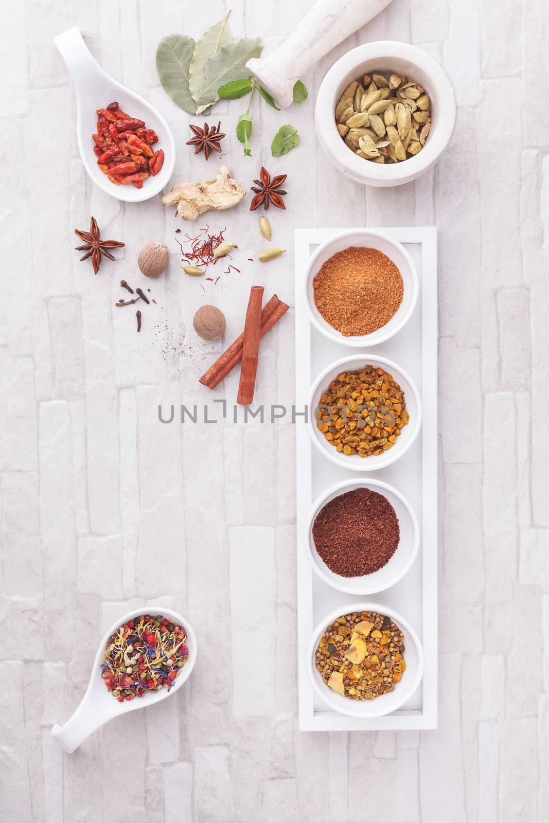 Assorted spices in ceramic dishes on a desk. Overhead view with retro style processing. Natural light