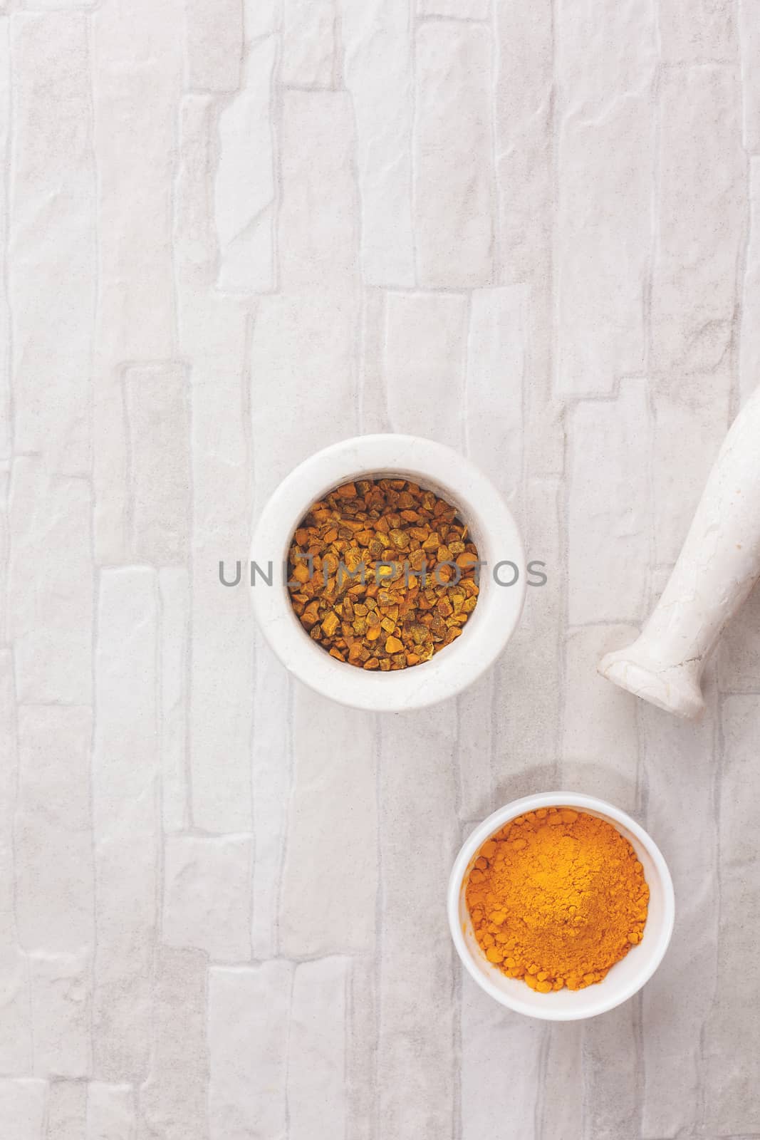 Turmeric spice in and beside a mortar. Top view, blank space, vintage toned image.