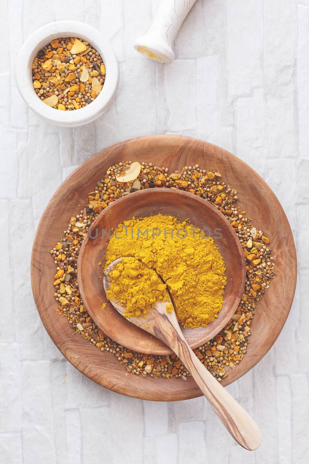 Curry spices in a shallow bowl with a spoon. Top view, blank space, vintage toned image. Natural light