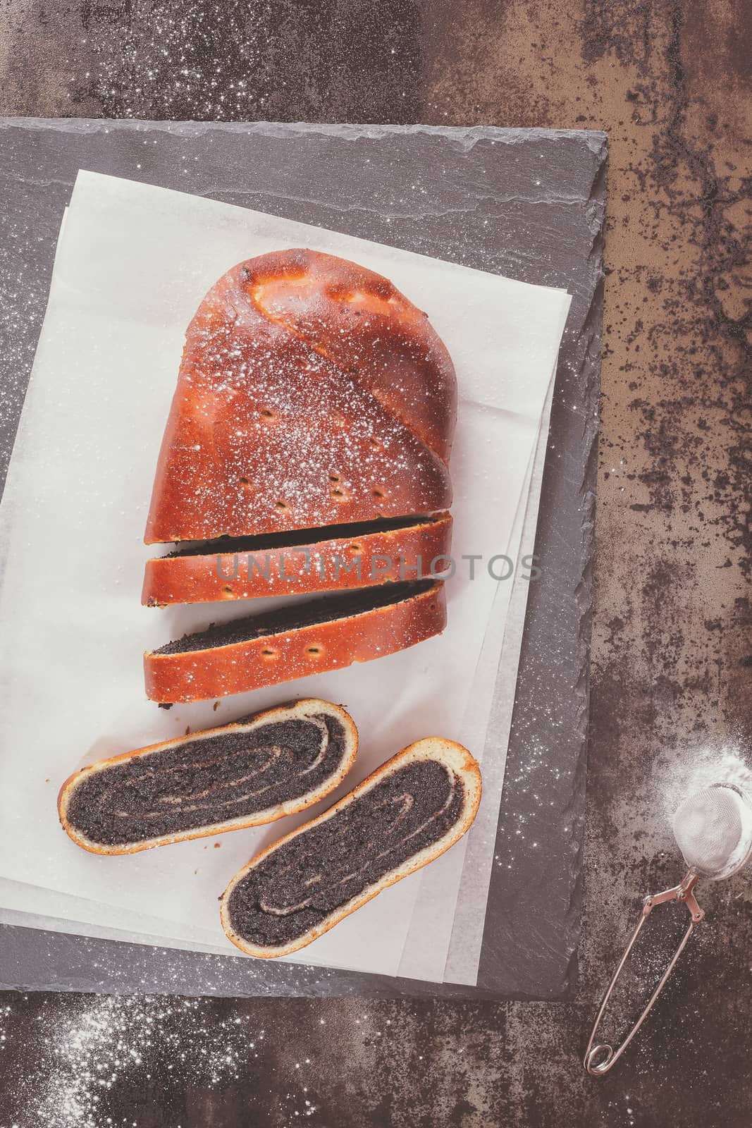 Poppy seed strudel, partly slices on vintage background. Overhead view with copy space. Natural light